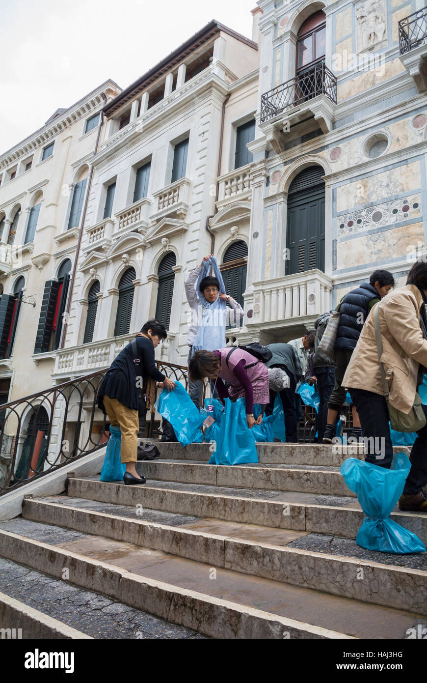 I turisti giapponesi mettendo stivali di gomma Venezia Italia Foto stock -  Alamy