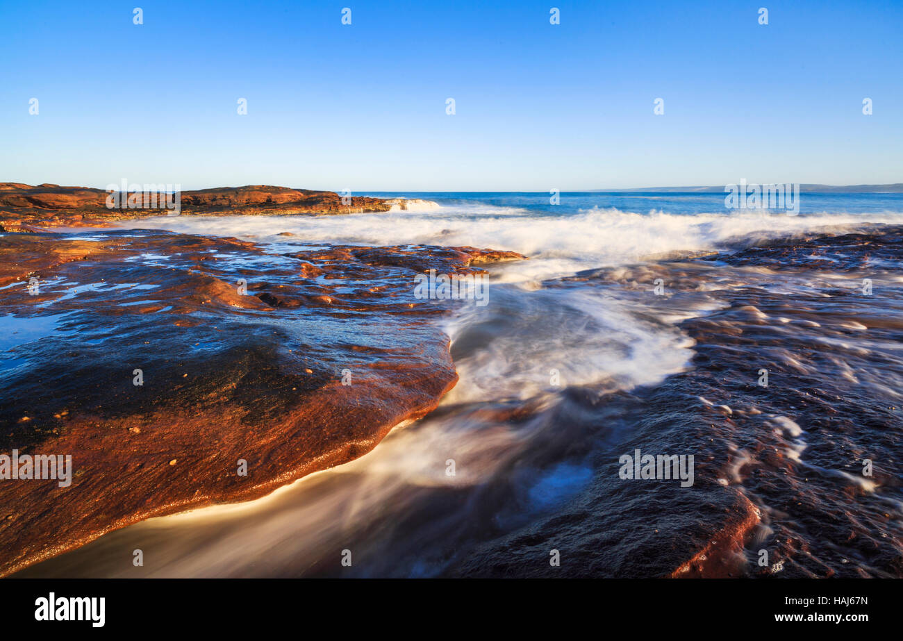 Onde che si infrangono sulle rocce arenarie litorale sotto Red Bluff di Kalbarri National Park Foto Stock