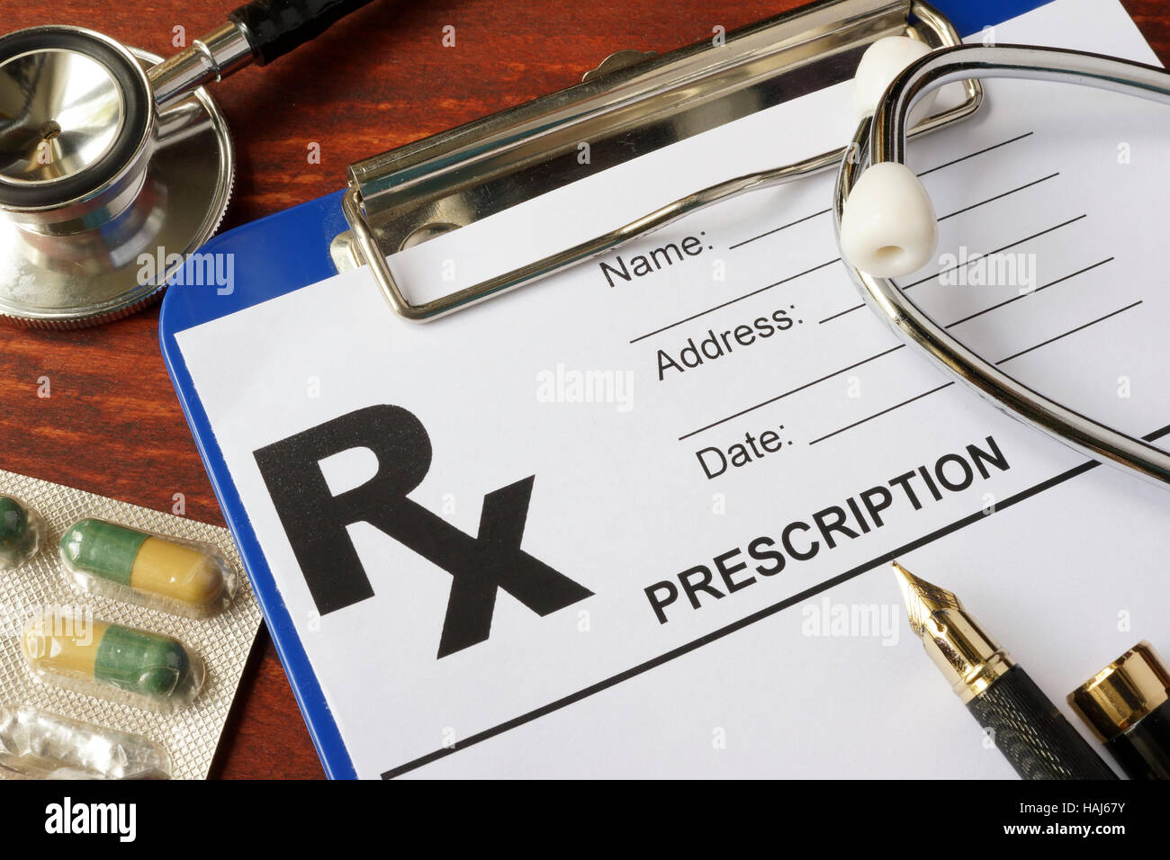 Modulo di prescrizione su un tavolo con uno stetoscopio e farmaci. Foto Stock