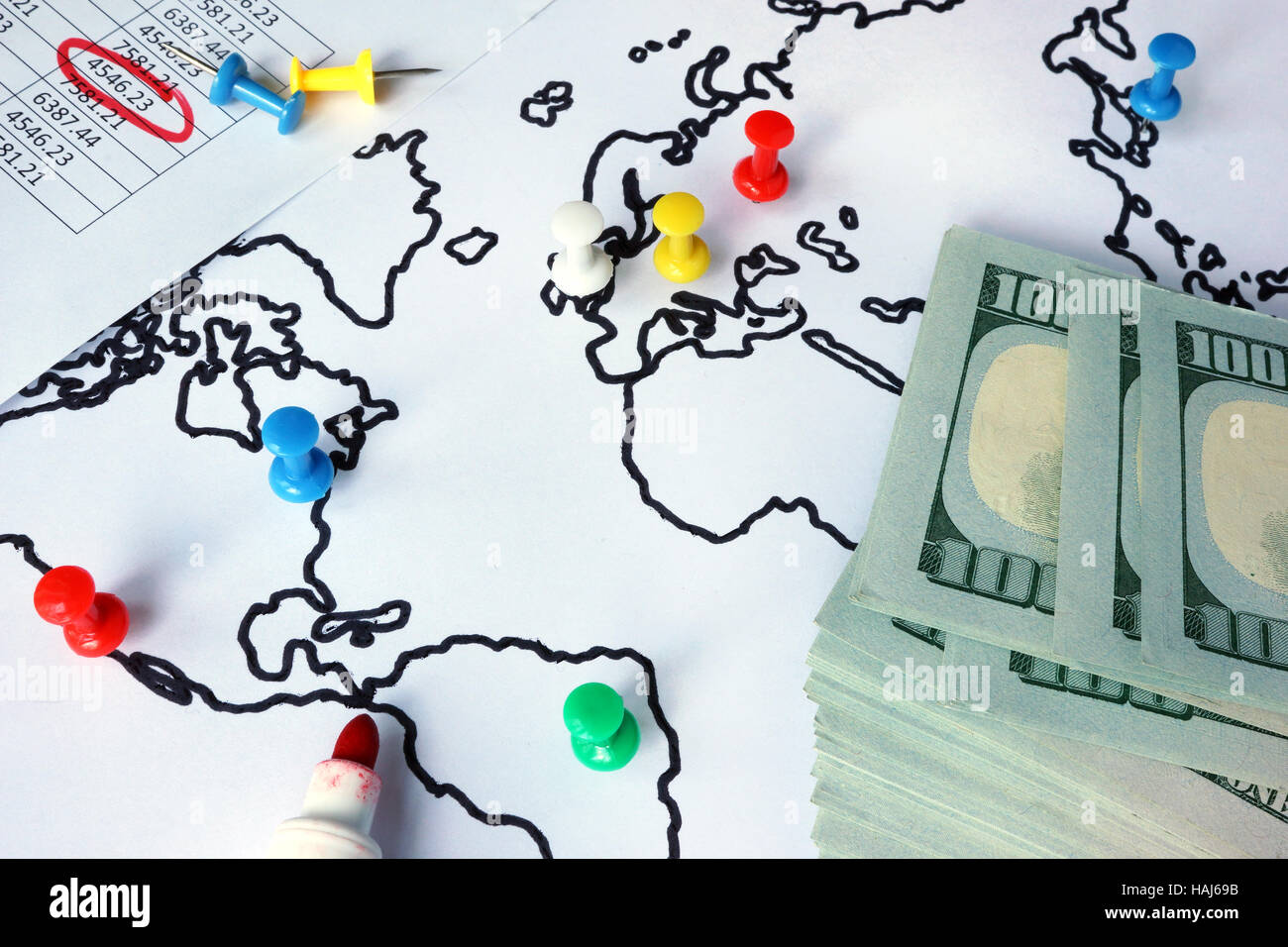 Pollice chiodini in una mappa del mondo e contanti. Anti-riciclaggio di denaro (AML) concetto Foto Stock