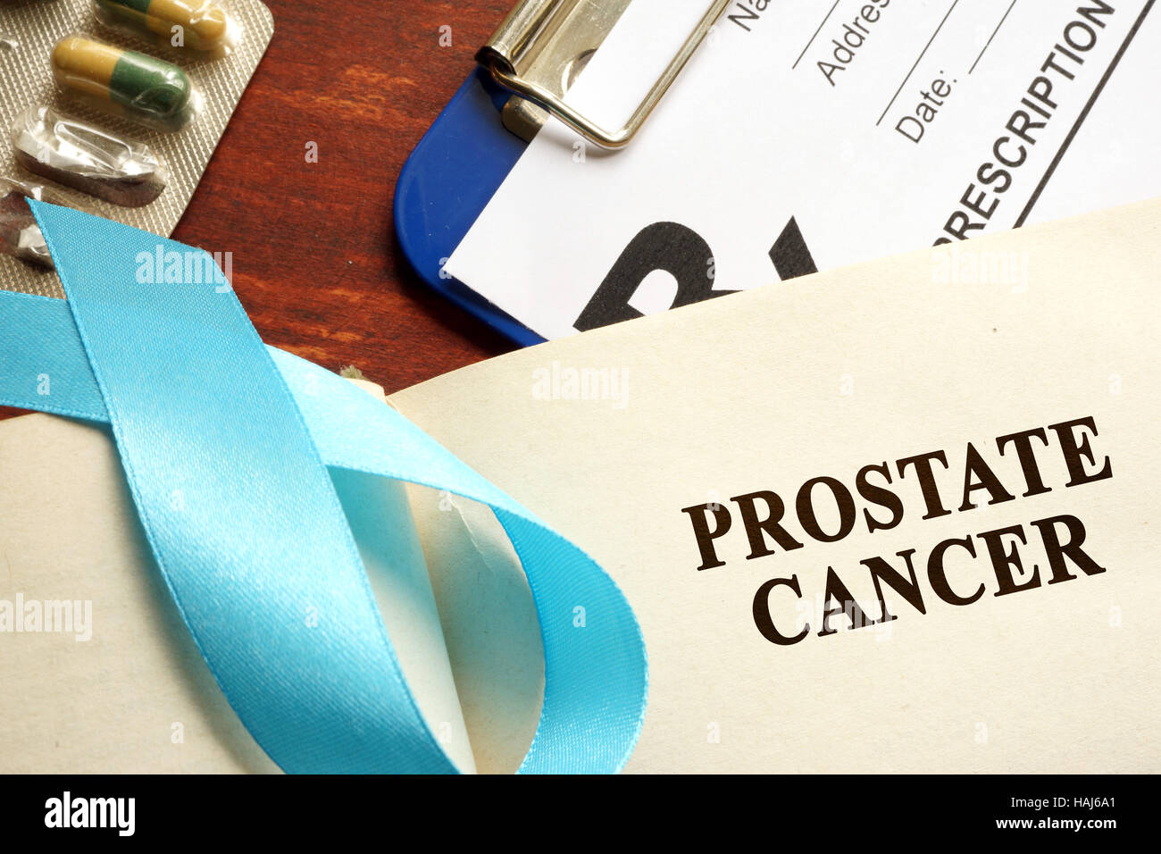 Il cancro della prostata scritto su una pagina e consapevolezza blu ribbon. Foto Stock
