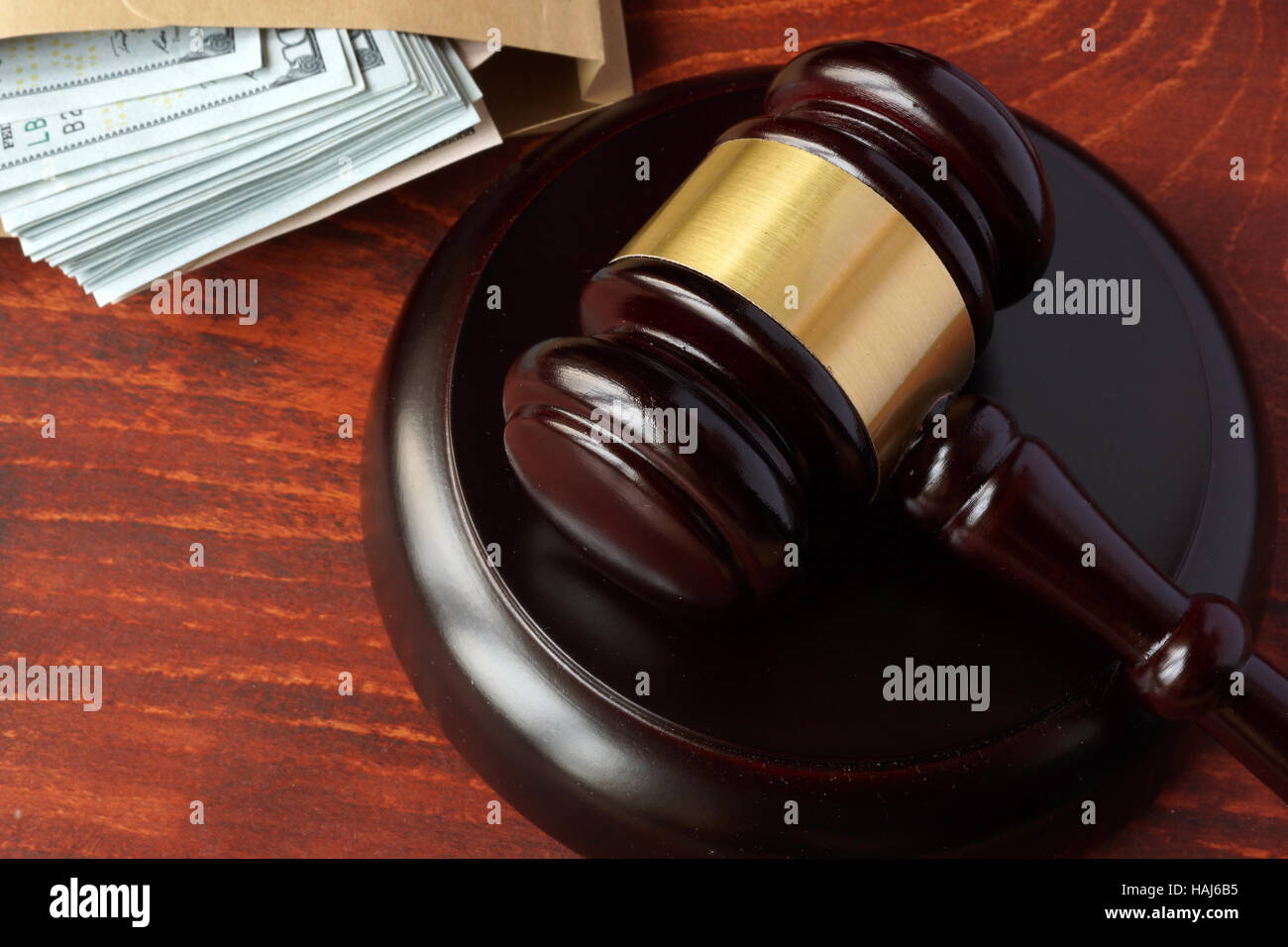 La corruzione in un concetto di corte. Il martello e il denaro su un tavolo. Foto Stock