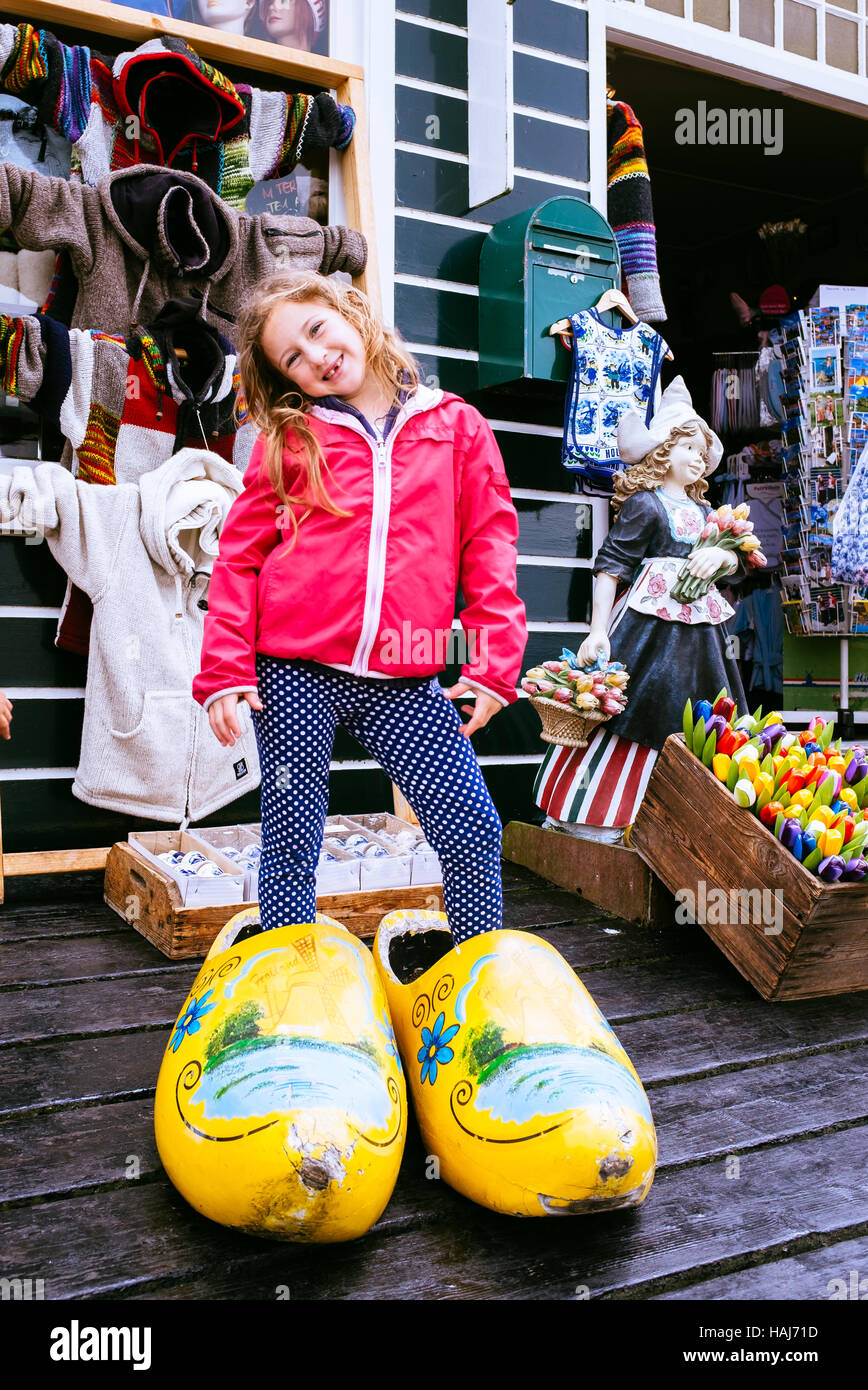 Bambina in posa tipica olandese enormi zoccoli di legno davanti a un  negozio di souvenir a Volendam, Paesi Bassi Foto stock - Alamy