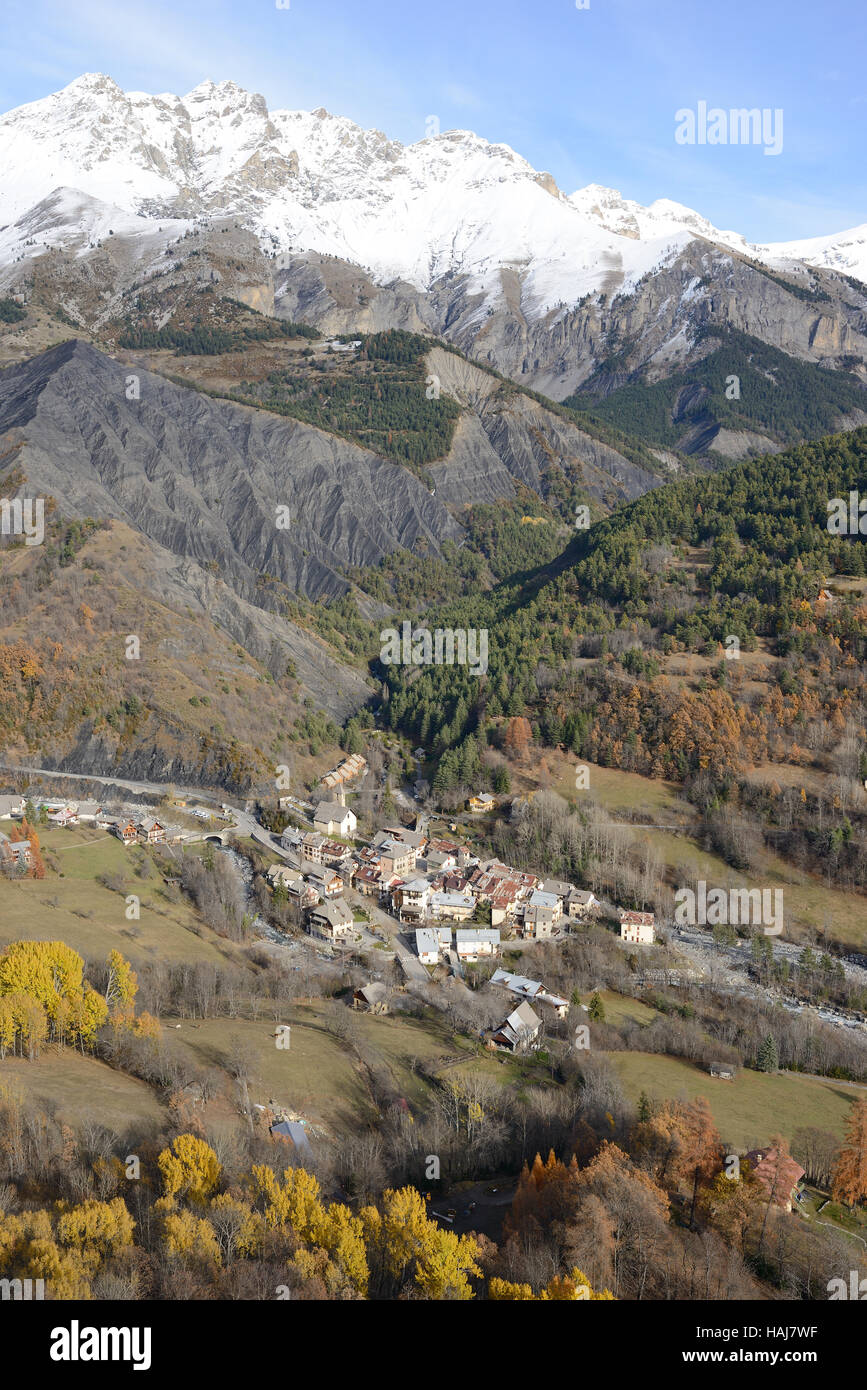 VISTA AEREA. Villaggio di Entraunes (1250m) ai piedi del picco Roche Grande (2751m) nella Valle del Var superiore. Alpes-Maritimes, Francia. Foto Stock