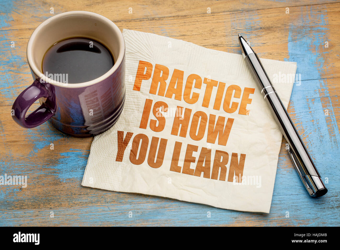 La pratica è il modo in cui il vostro apprendimento - il testo su un tovagliolo con una tazza di caffè espresso Foto Stock