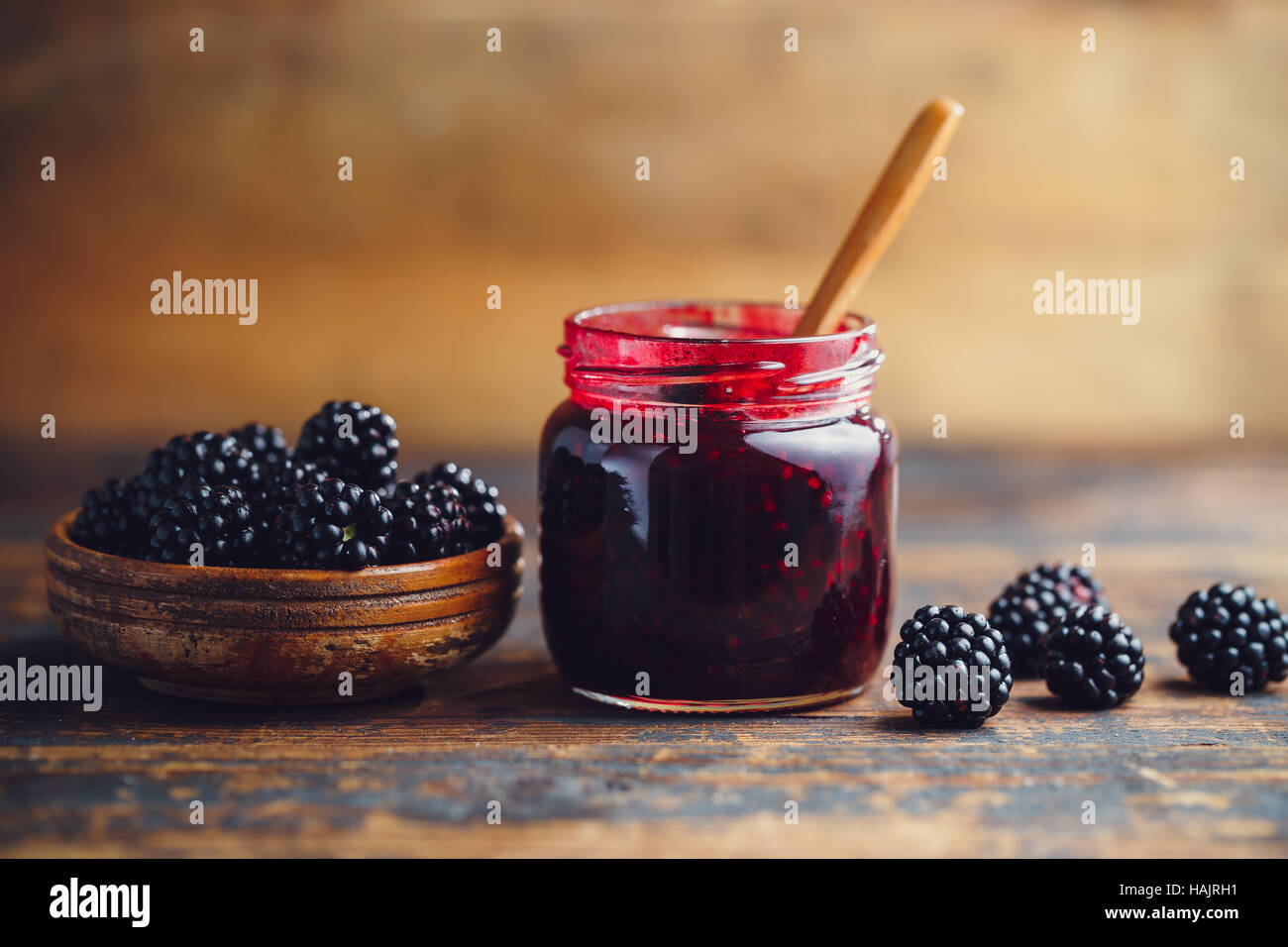 Freschi Fatti in casa marmellata di blackberry in un barattolo di vetro su uno sfondo di legno Foto Stock