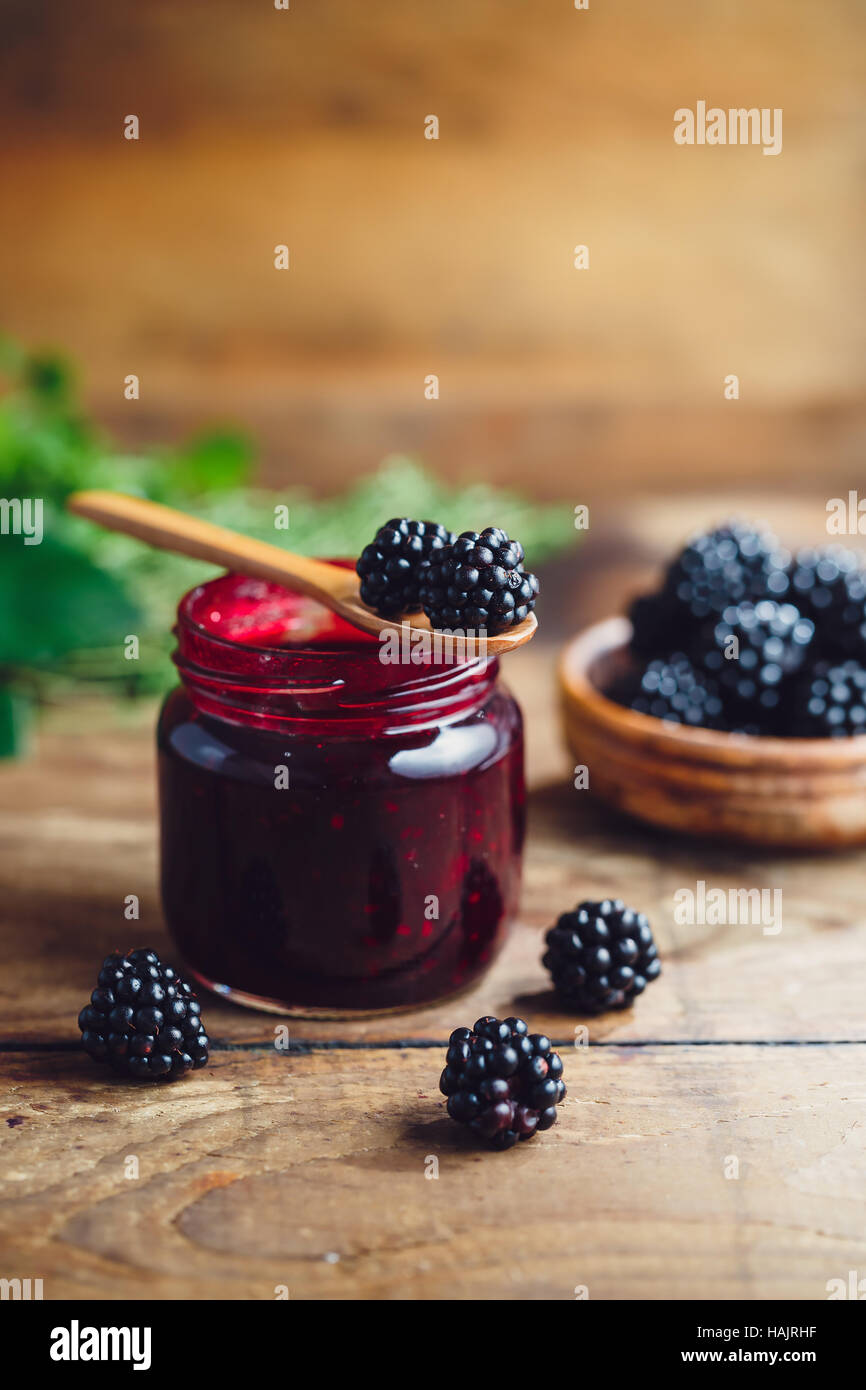 Freschi Fatti in casa marmellata di blackberry in un barattolo di vetro su uno sfondo di legno Foto Stock