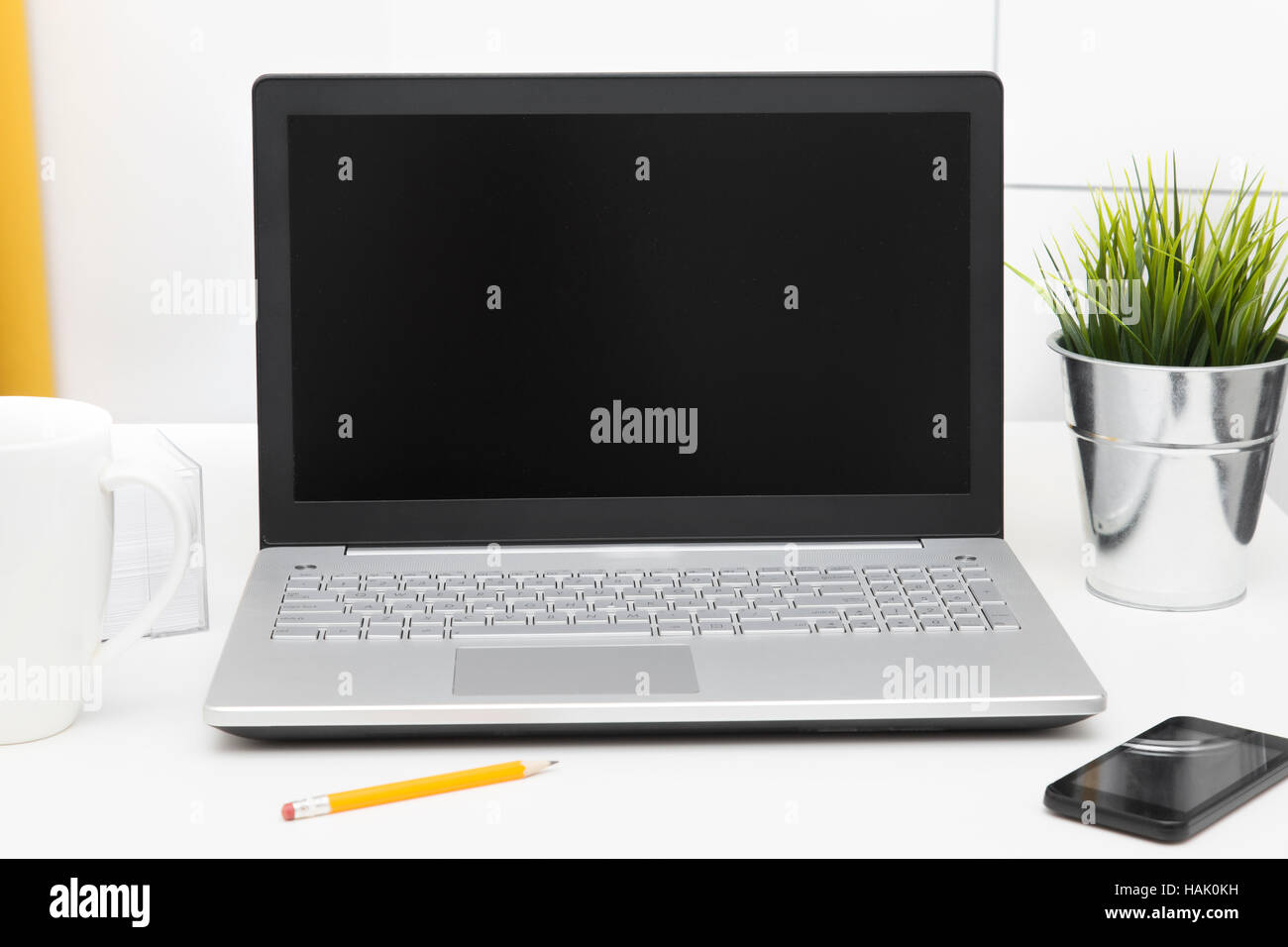 Computer portatile con schermo bianco su bianco tabella Foto Stock