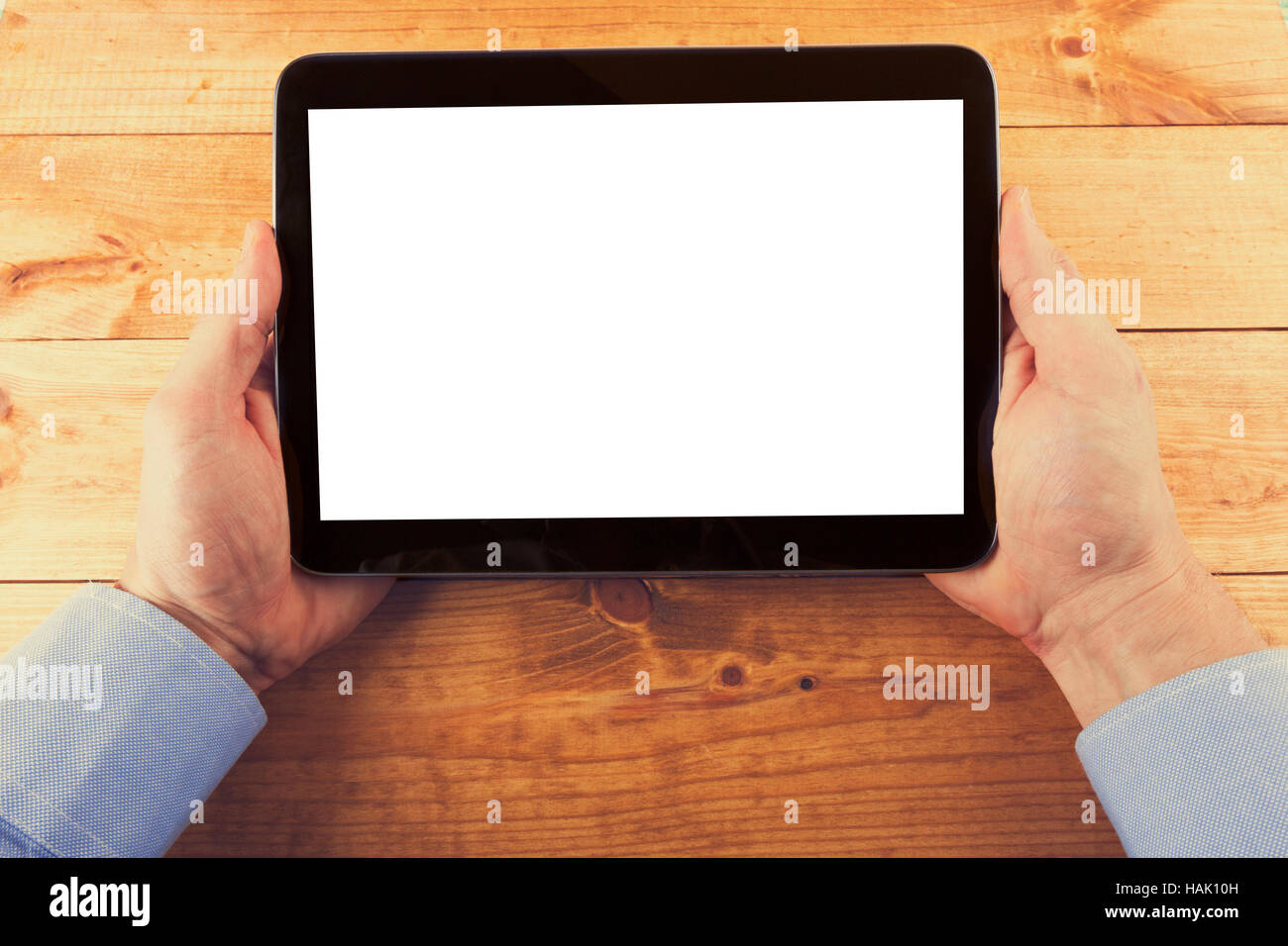 Tavoletta digitale con schermo vuoto in mani sul tavolo di legno Foto Stock