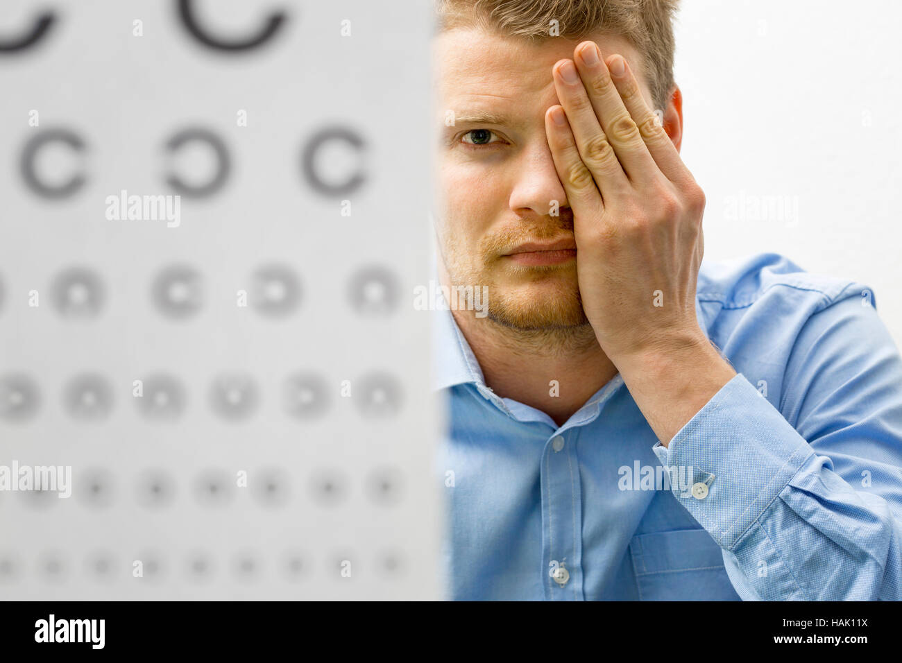 Controllo della vista. paziente di sesso maschile sotto visione esame Foto Stock