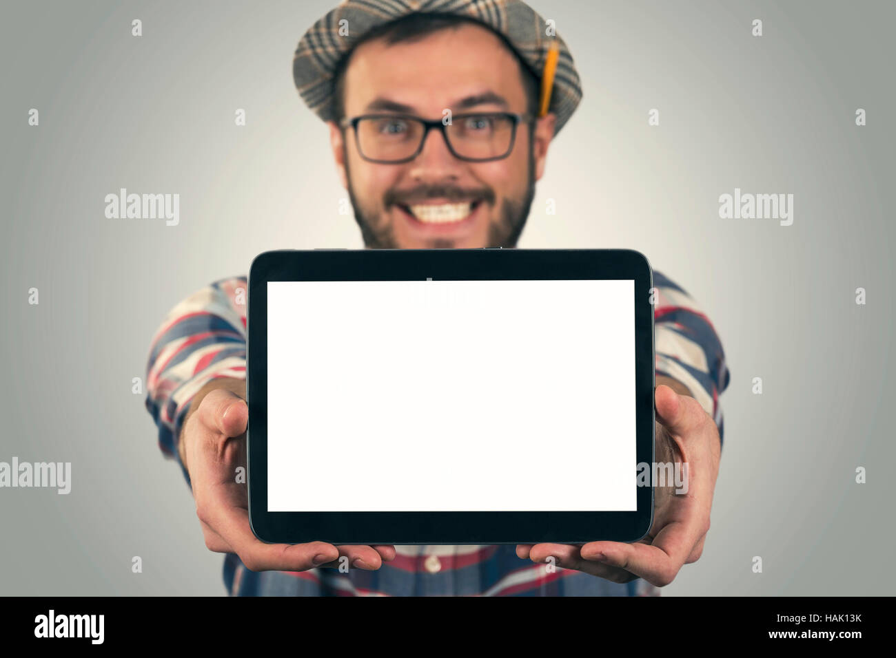 Giovani attraenti felice l'uomo che mostra vuoto tavoletta digitale Foto Stock