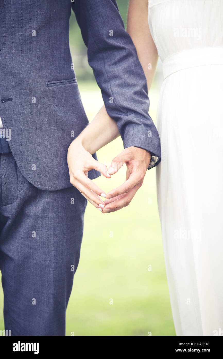Matrimonio - sposa e il suo fidanzato che mostra il cuore con le mani Foto Stock