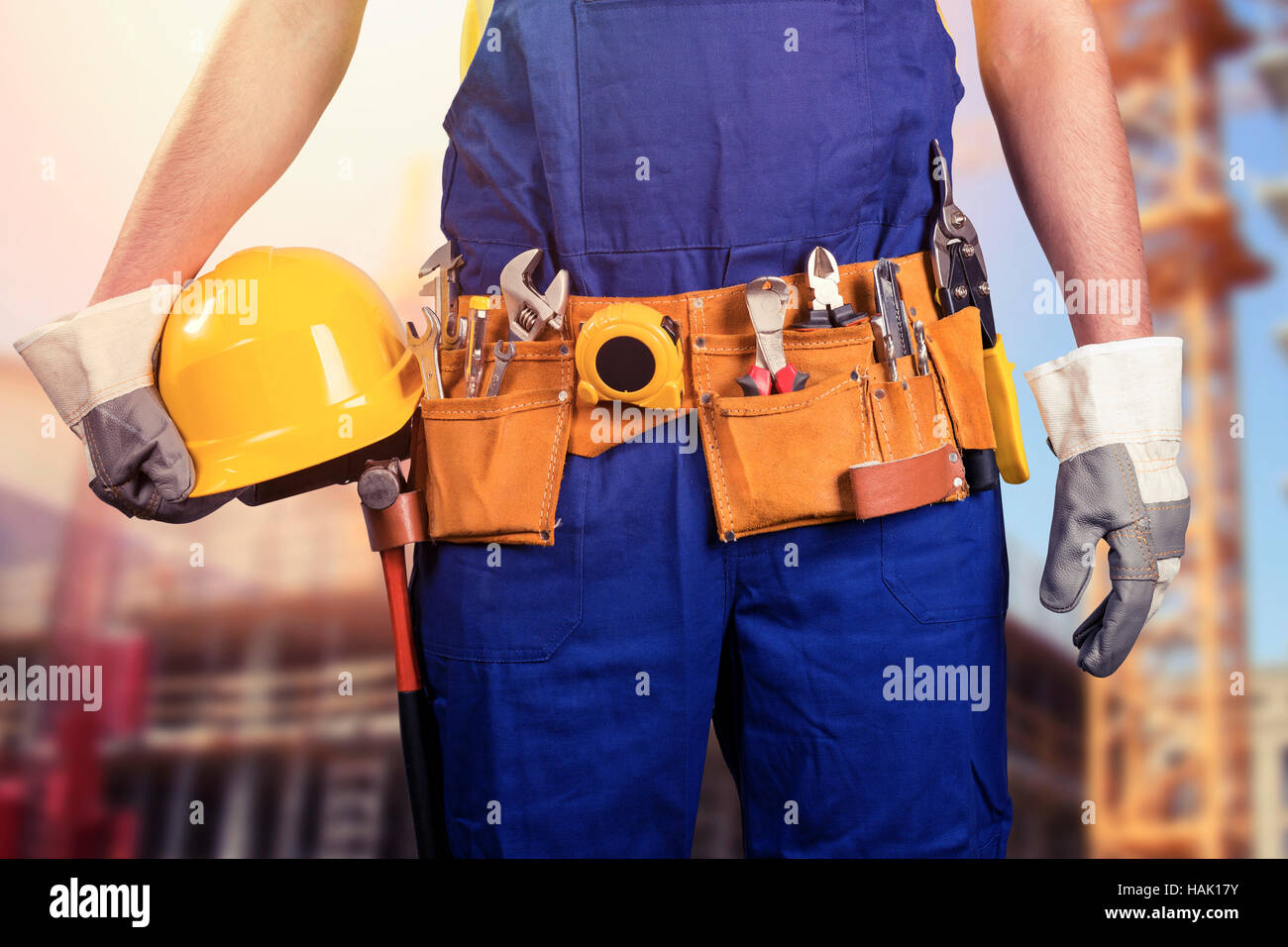 Lavoratore edile con utensile cinghia al sito di costruzione Foto Stock