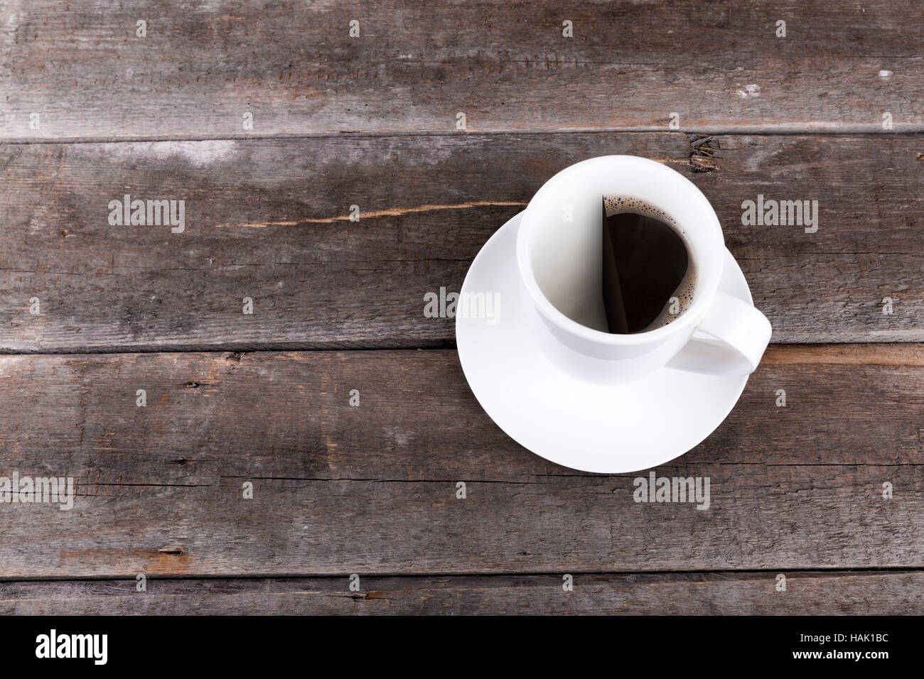 Mezza tazza di caffè sul tavolo in legno con copysace Foto Stock