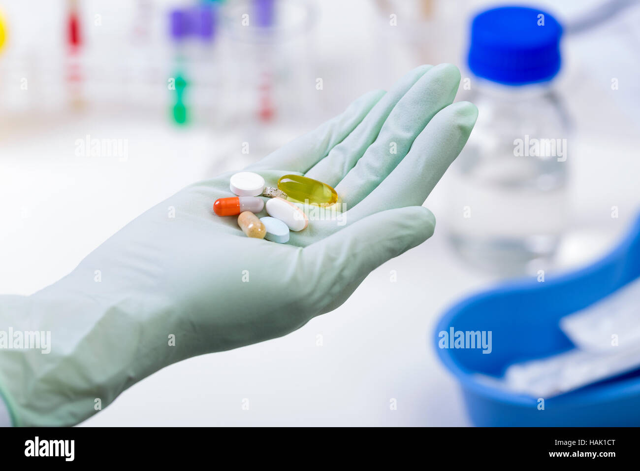 Pillole di medici in una mano del lavoratore di laboratorio Foto Stock
