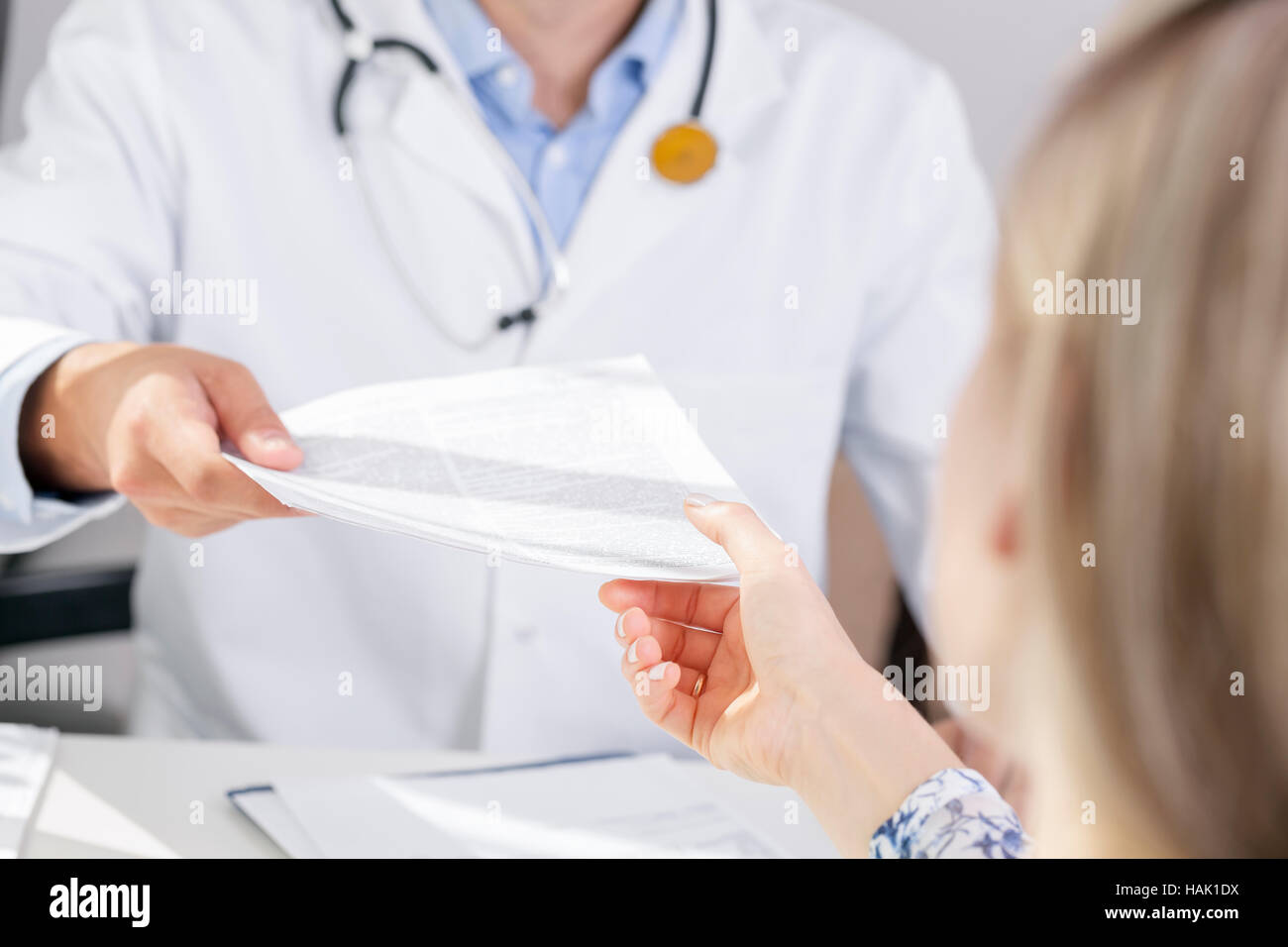Medico dare un documento paziente Foto Stock