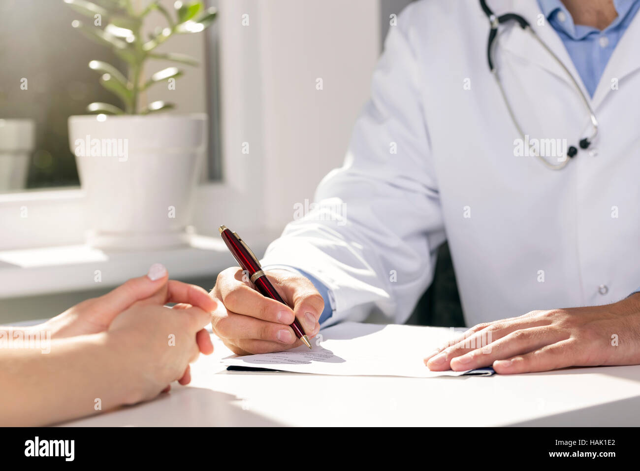 La consultazione del medico - il medico e il paziente seduto da tavolo Foto Stock