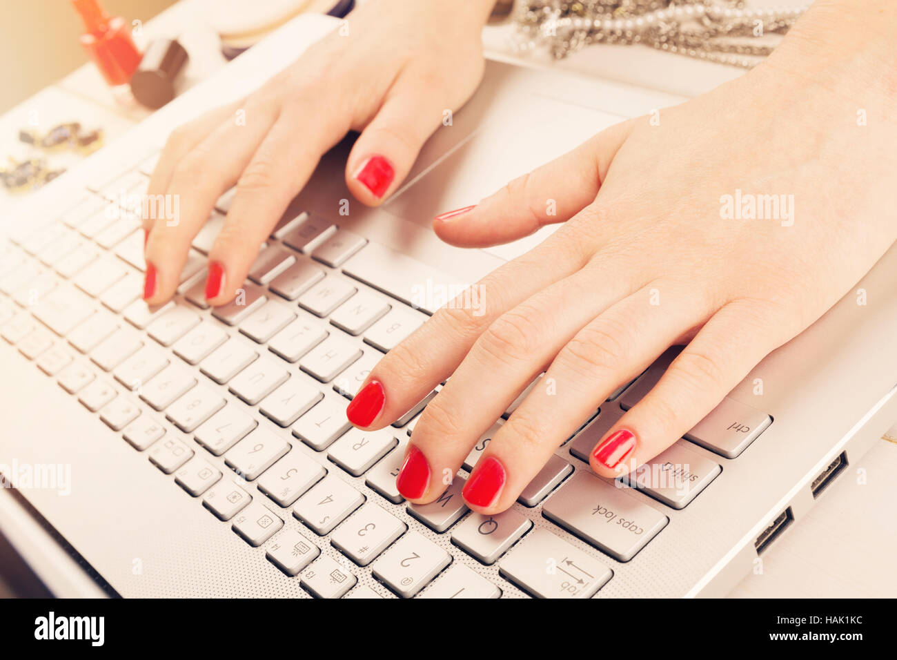 Moda Donna rosso con chiodi lucidato a lavorare sul laptop. scrittura blog concept Foto Stock