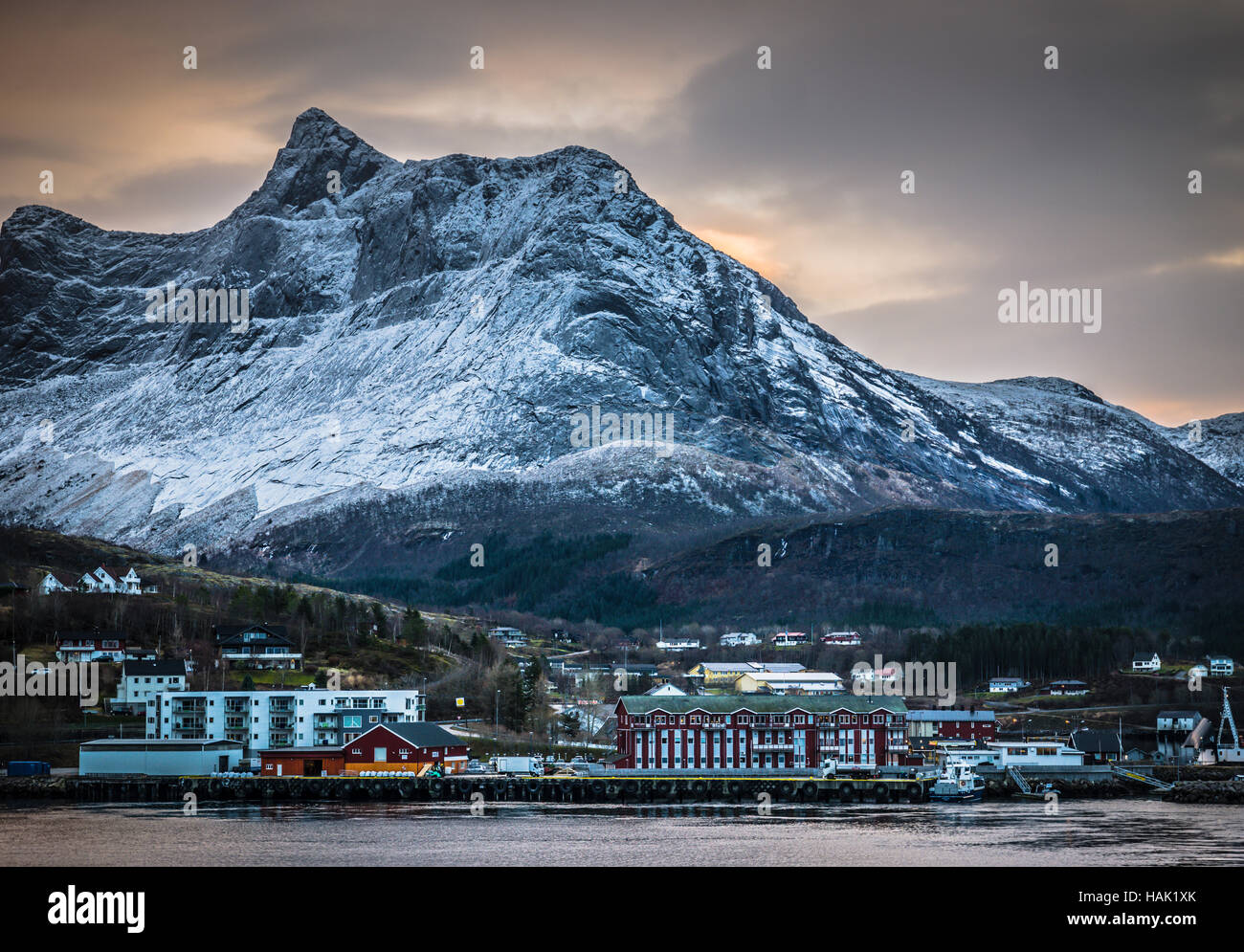 Alloggiamento moderno all'ombra delle montagne innevate a Ornes, Nordland, Norvegia settentrionale. Foto Stock