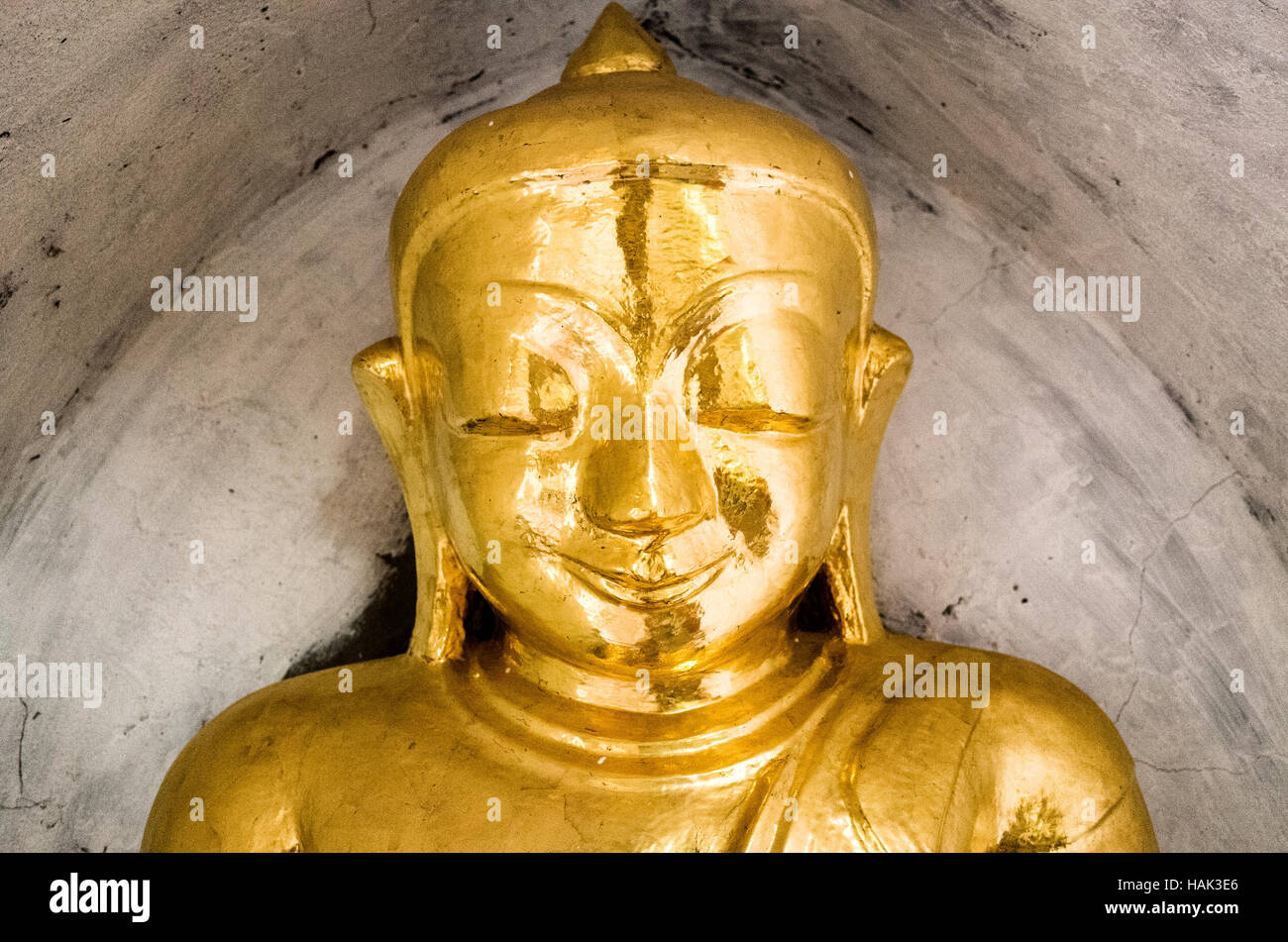 Una piccola statua dorata del Buddha in un'alcova al tempio Thatbyinnyu. Costruito nel XII secolo, Thatbyinnyu tempio è uno dei più importanti templi a Bagan Zona archeologica e sorge adiacente al famoso tempio di Ananda. Foto Stock