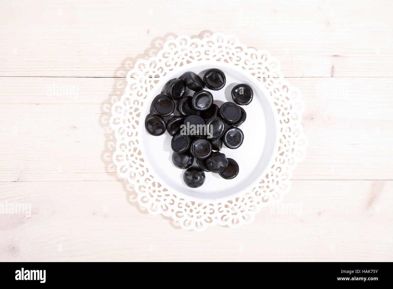 Tradizionali olandesi candy drop sulla piastrina su sfondo di legno Foto Stock