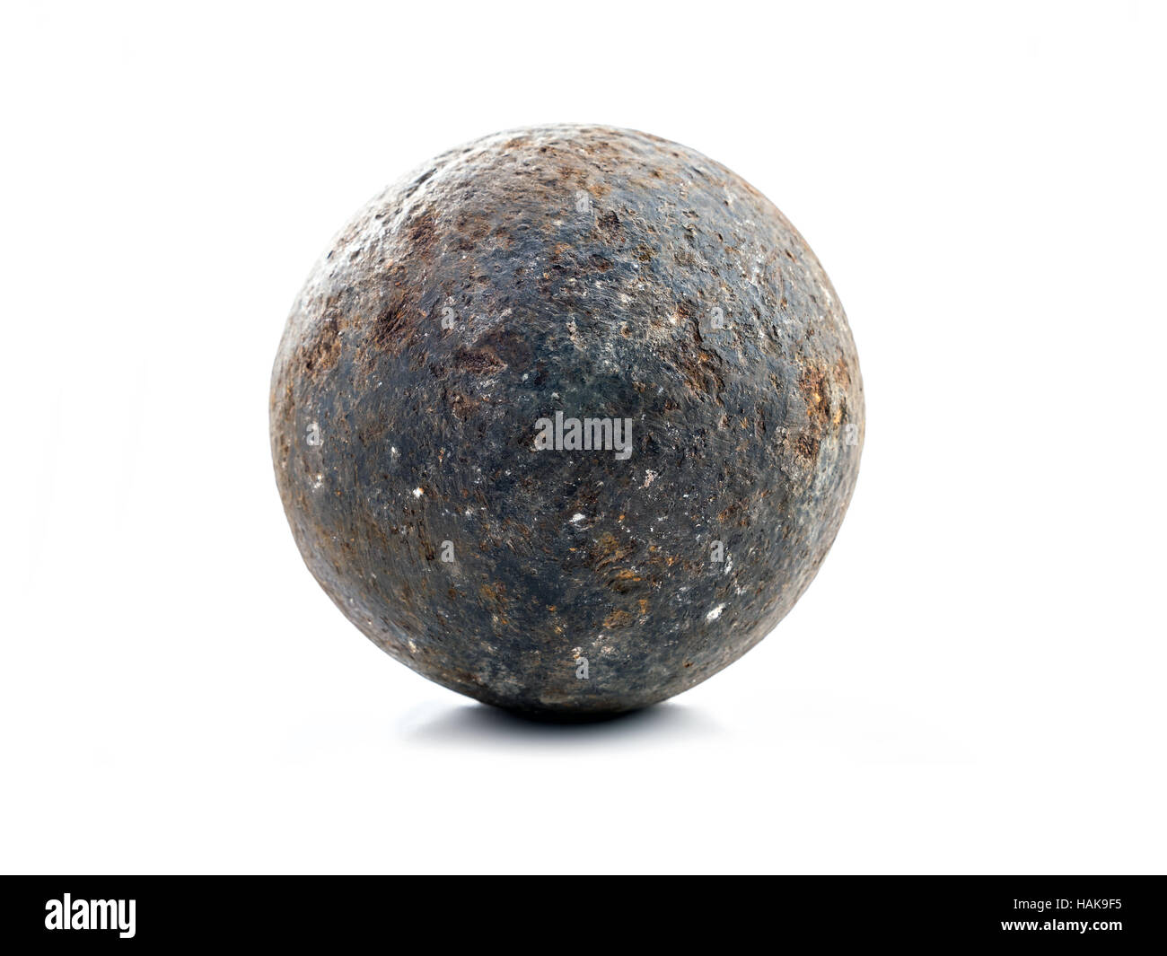 Vecchio arrugginito palla di cannone sparato su bianco Foto Stock
