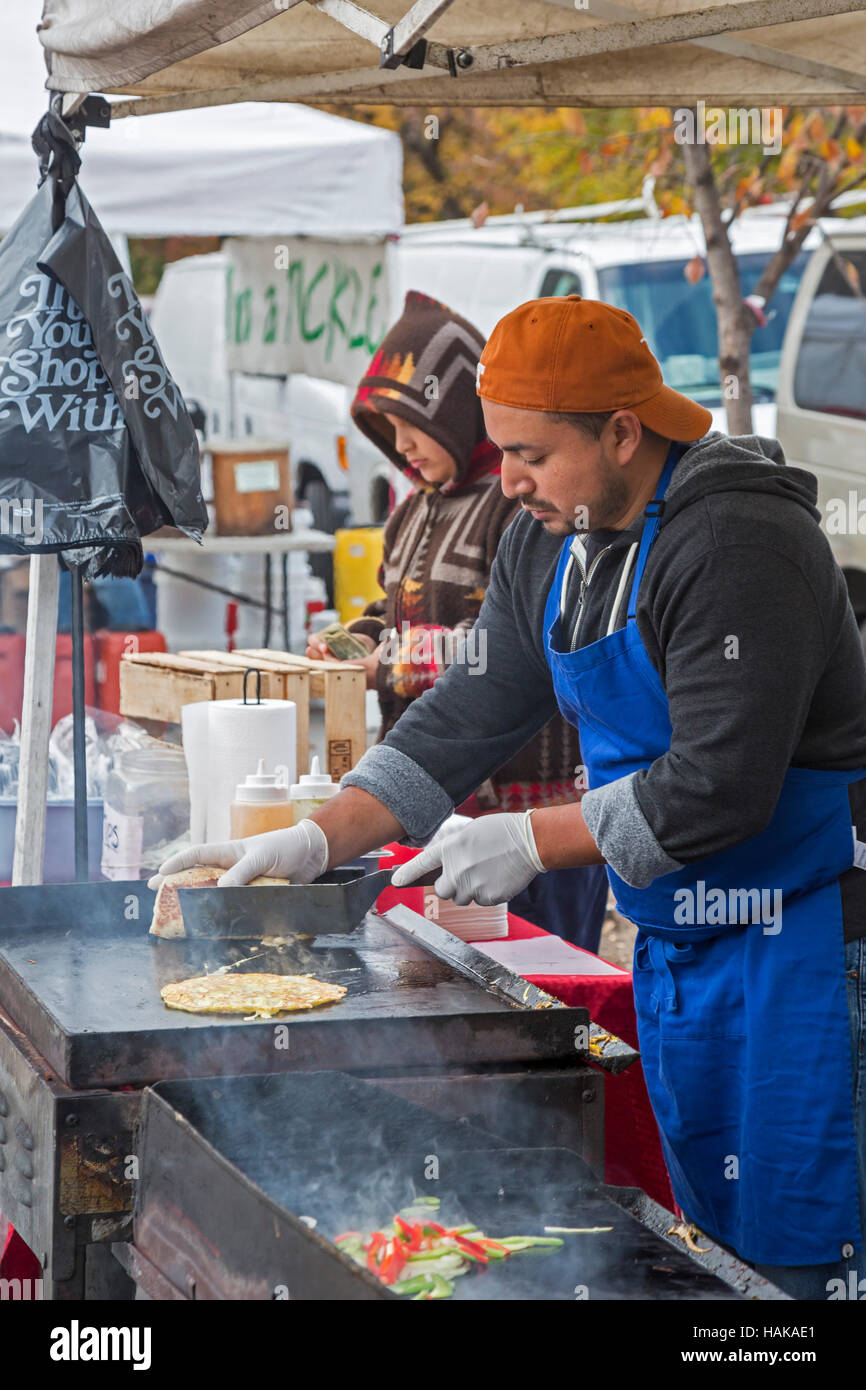 Washington, DC - un uomo cuoce ad un cibo all'aperto stand nello storico mercato orientale. Foto Stock