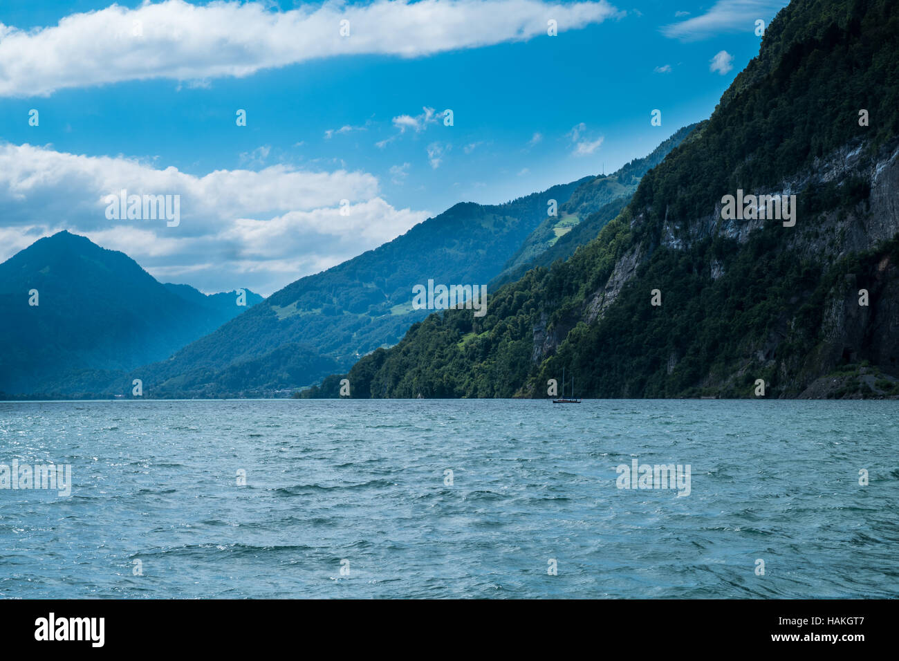 La vista mozzafiato sul lago con barche su di esso e le montagne sullo sfondo in Svizzera Foto Stock
