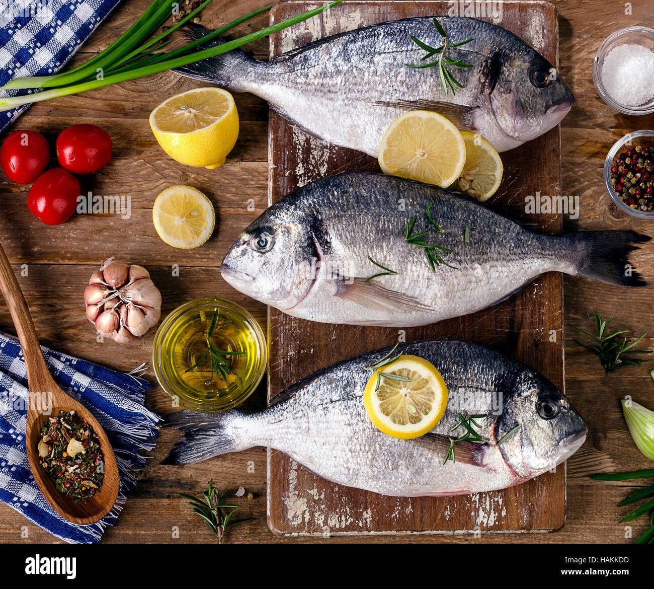 Pesce fresco con erbe aromatiche, le spezie e le verdure su un rustico sfondo di legno. Cibo sano concetto. Vista superiore Foto Stock