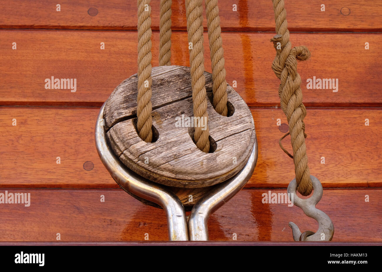 Close-up di una corda con una estremità annodata legato attorno un gancio su un molo in legno/ cima nautica Foto Stock