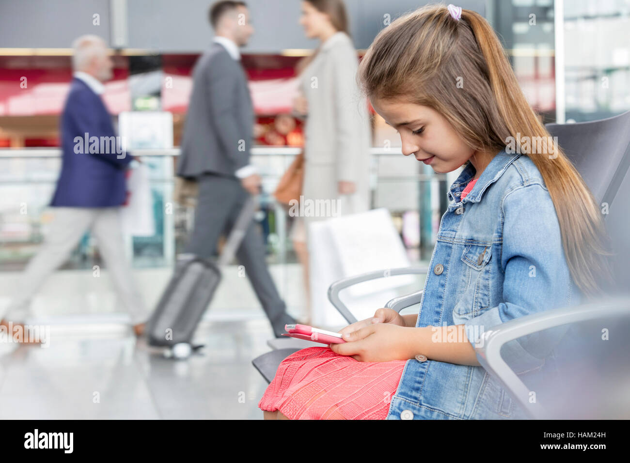 Ragazza con tavoletta digitale in aeroporto area di partenza Foto Stock