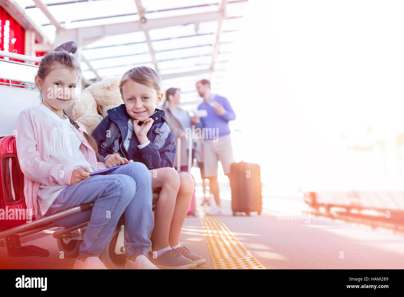 Ritratto sorridente fratello e sorella in attesa fuori dall aeroporto Foto Stock