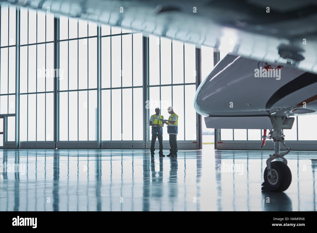 Il controllo del traffico aereo il personale a terra i lavoratori parlano in hangar aereo Foto Stock
