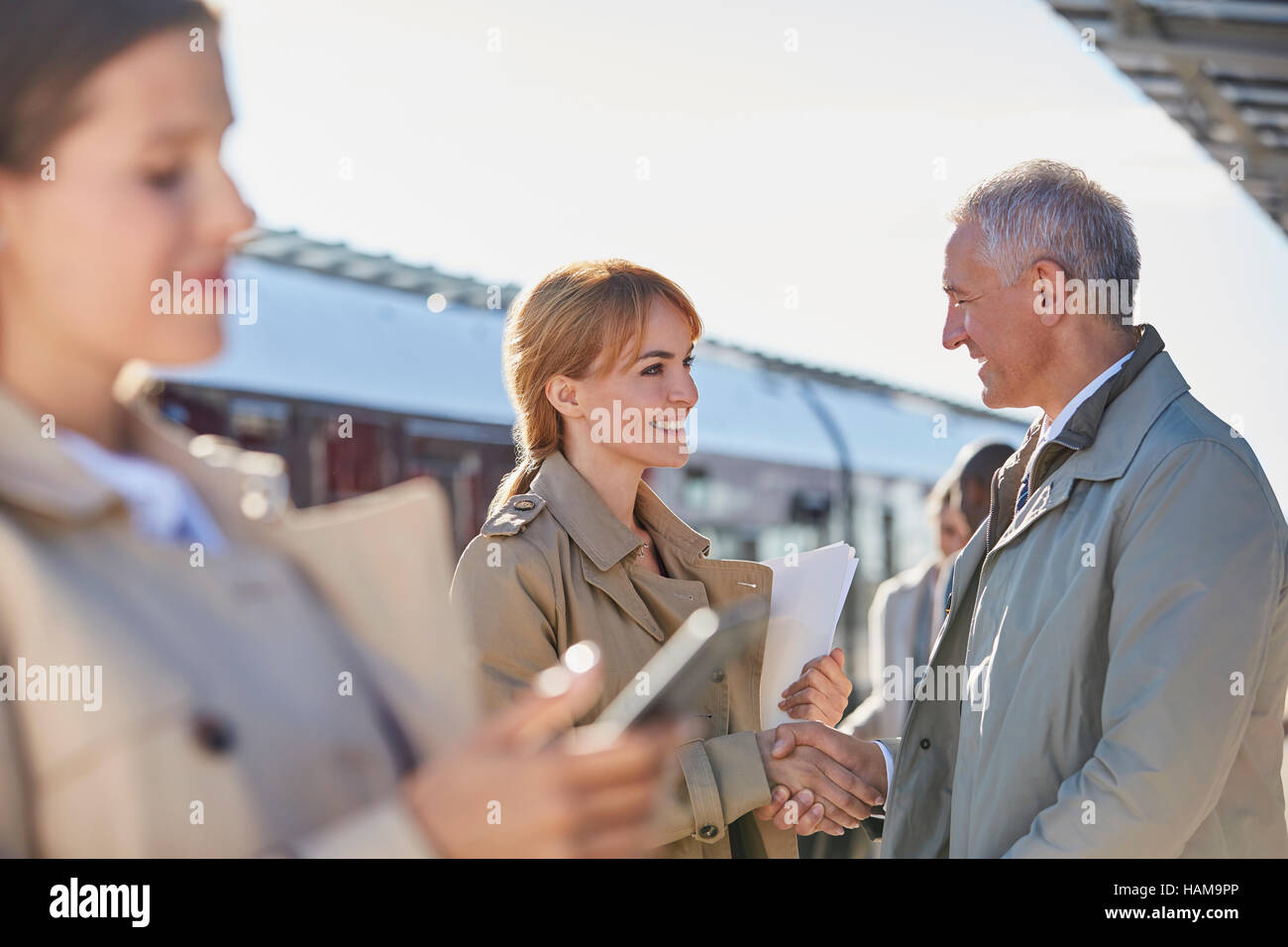 Imprenditore e imprenditrice di handshaking soleggiata sulla stazione ferroviaria platform Foto Stock