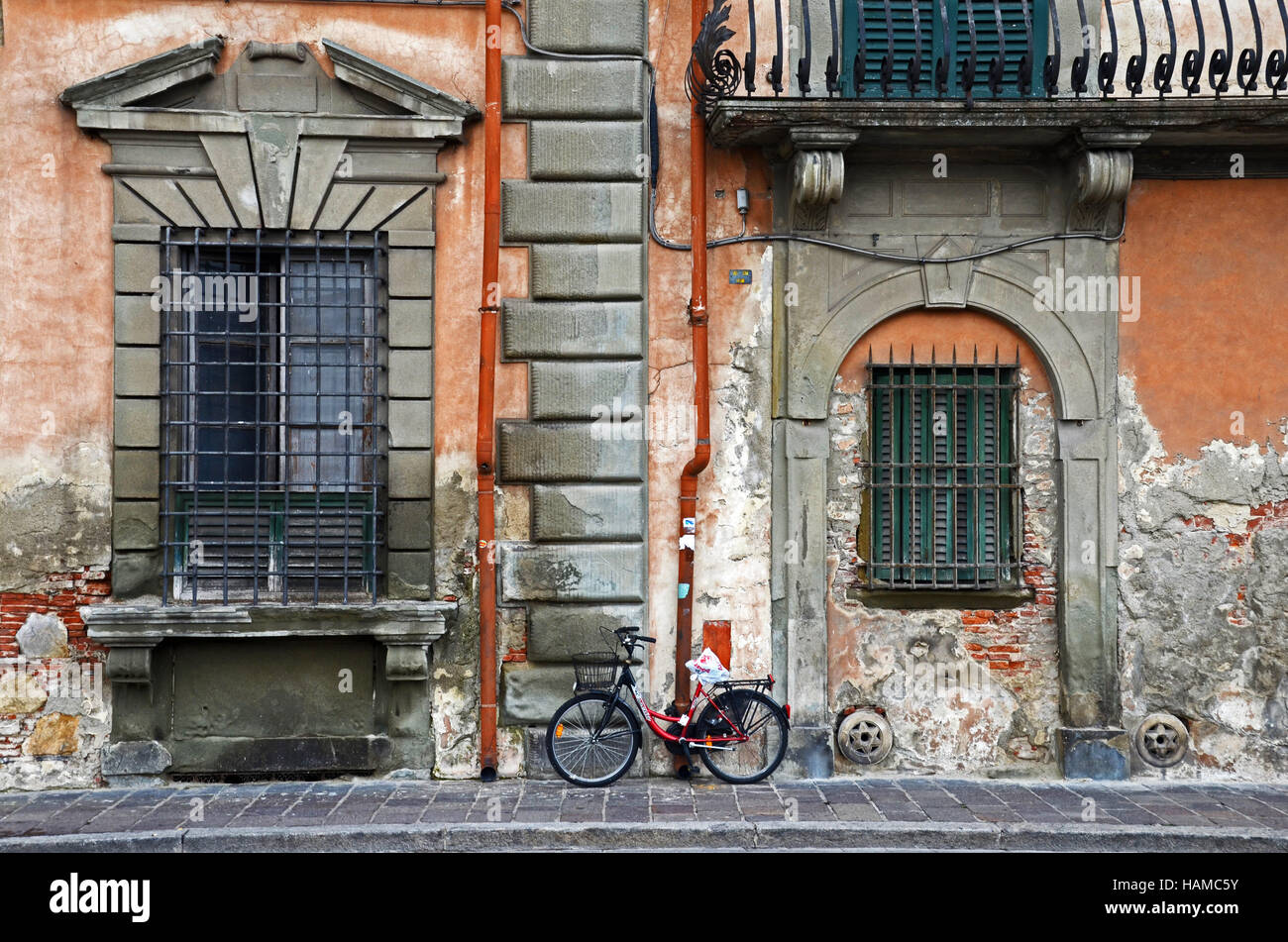 Una bicicletta si appoggia contro un vecchio edificio, Pisa, Toscana, Italia Foto Stock
