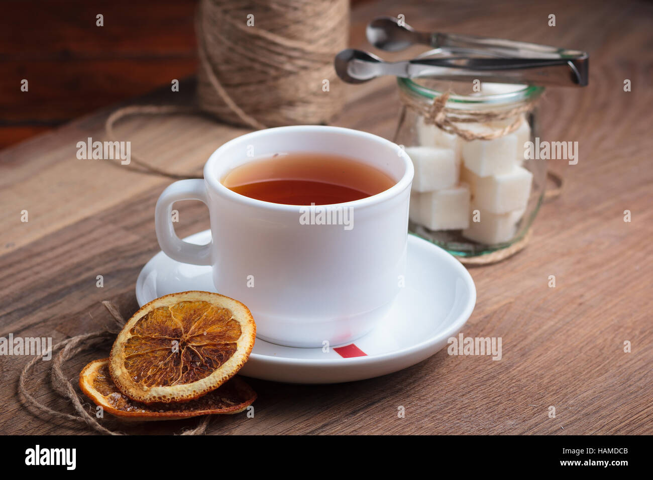 Concetto: ristorante menu, mangiare sano, fatti in casa, golosi, golosità. Il tè in tazza bianca con caramelle a spiovente sfondo di legno. Foto Stock