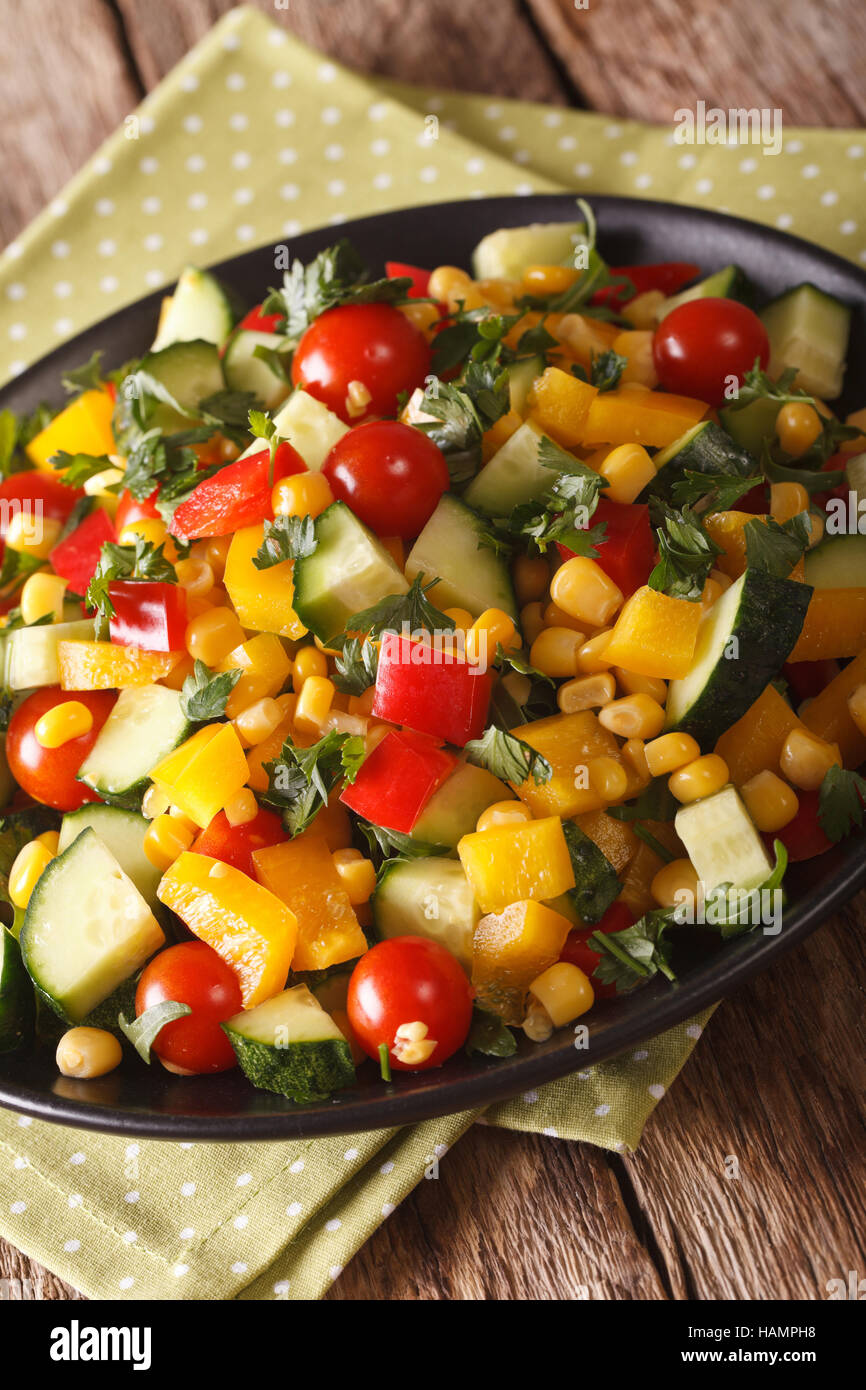 Verdura fresca insalata con mais, pomodori, cetrioli e pepe vicino sul piano verticale. Foto Stock