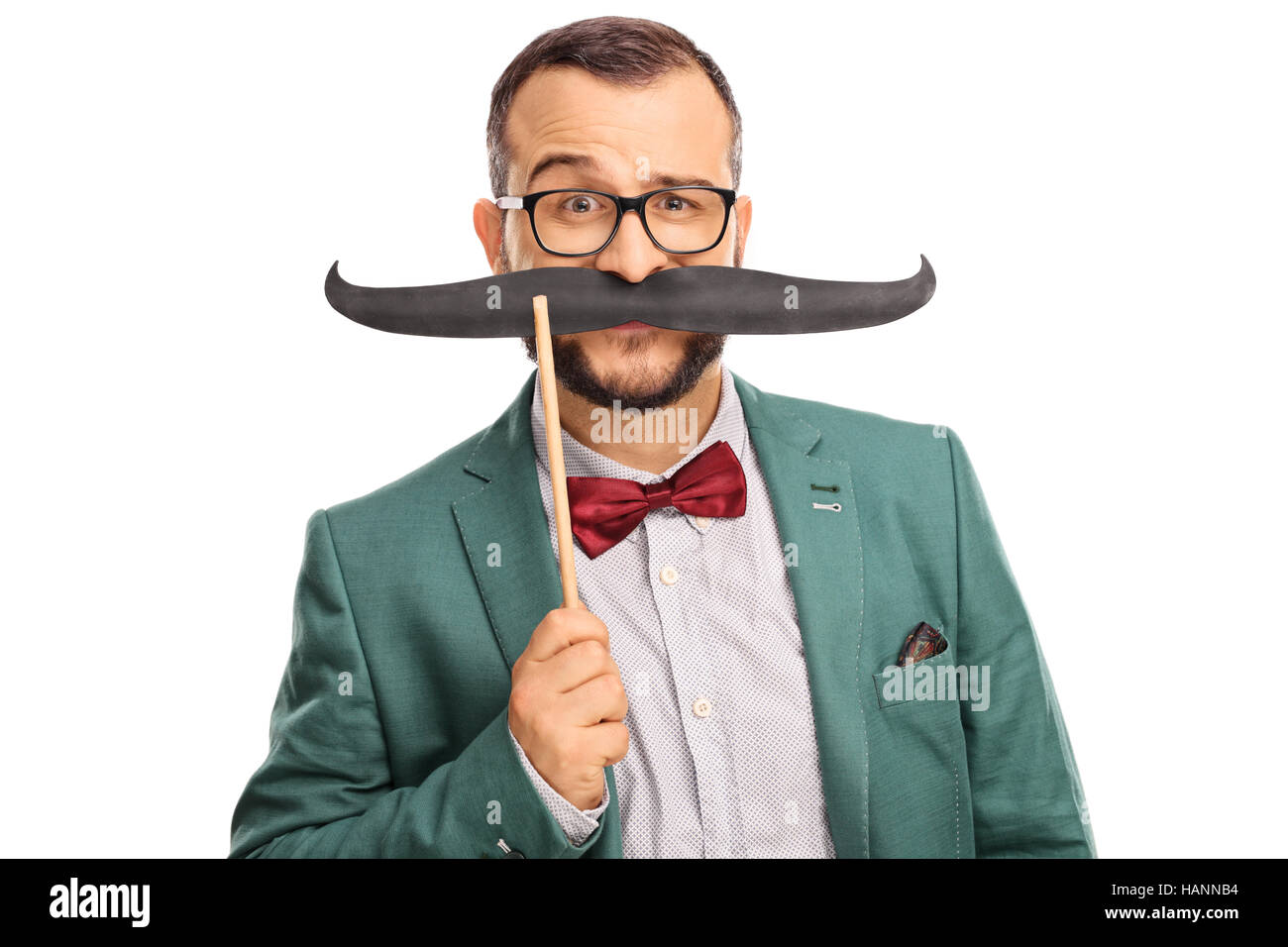 L'uomo vestito di un manto verde tenendo un fake baffi sul suo volto isolato su sfondo bianco Foto Stock