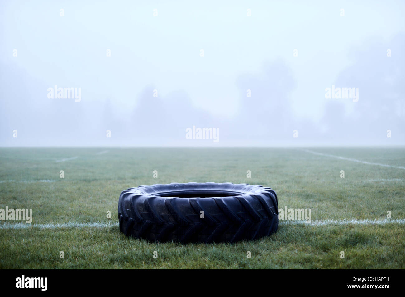 Pneumatico in gomma su foggy campo di calcio Foto Stock