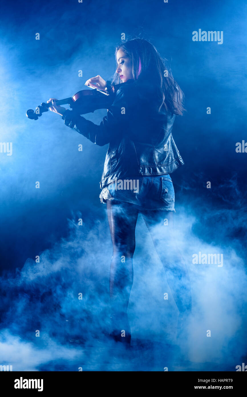 Rock donna con la giacca di pelle la riproduzione di un violino Foto Stock