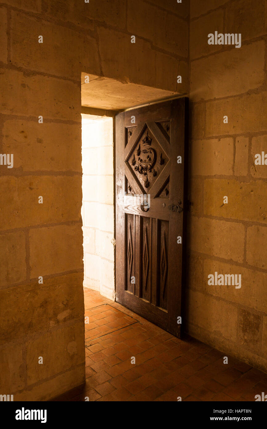 Colata di luce attraverso una porta e su un splendidamente scolpito porta di legno. La salamandra motif di François 1a può essere visto sulla porta. Questa parte Foto Stock