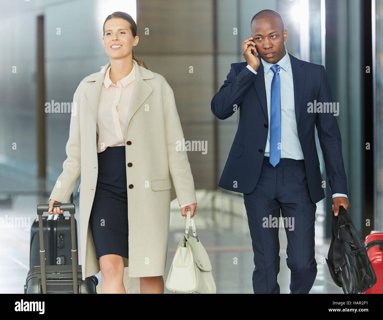 La gente di affari a piedi con i bagagli in aeroporto concourse Foto Stock