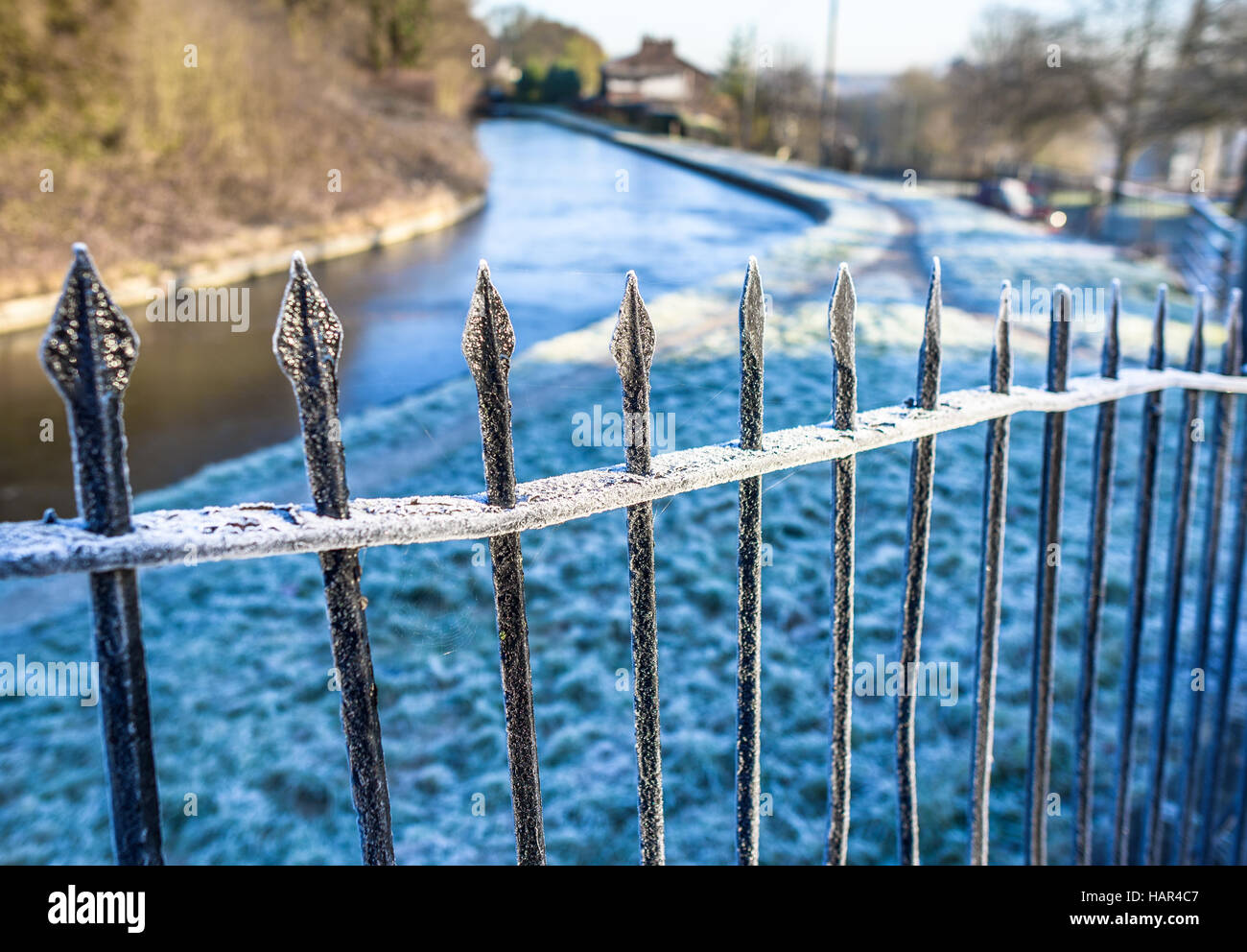Smerigliati vecchie ringhiere in ferro a fianco di un canale in inverno. Foto Stock