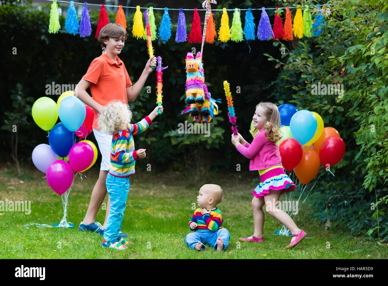 Kids festa di compleanno. Gruppo di bambini colpendo pinata, giocando con  palloncini. La famiglia e gli amici festeggia il compleanno all'aperto Foto  stock - Alamy