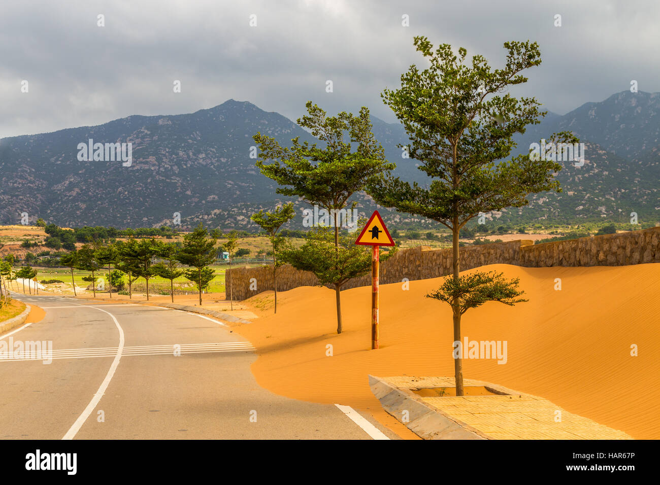 Un vuoto che la strada in Vietnam con sabbia costruito su di esso e sulle montagne sullo sfondo Foto Stock