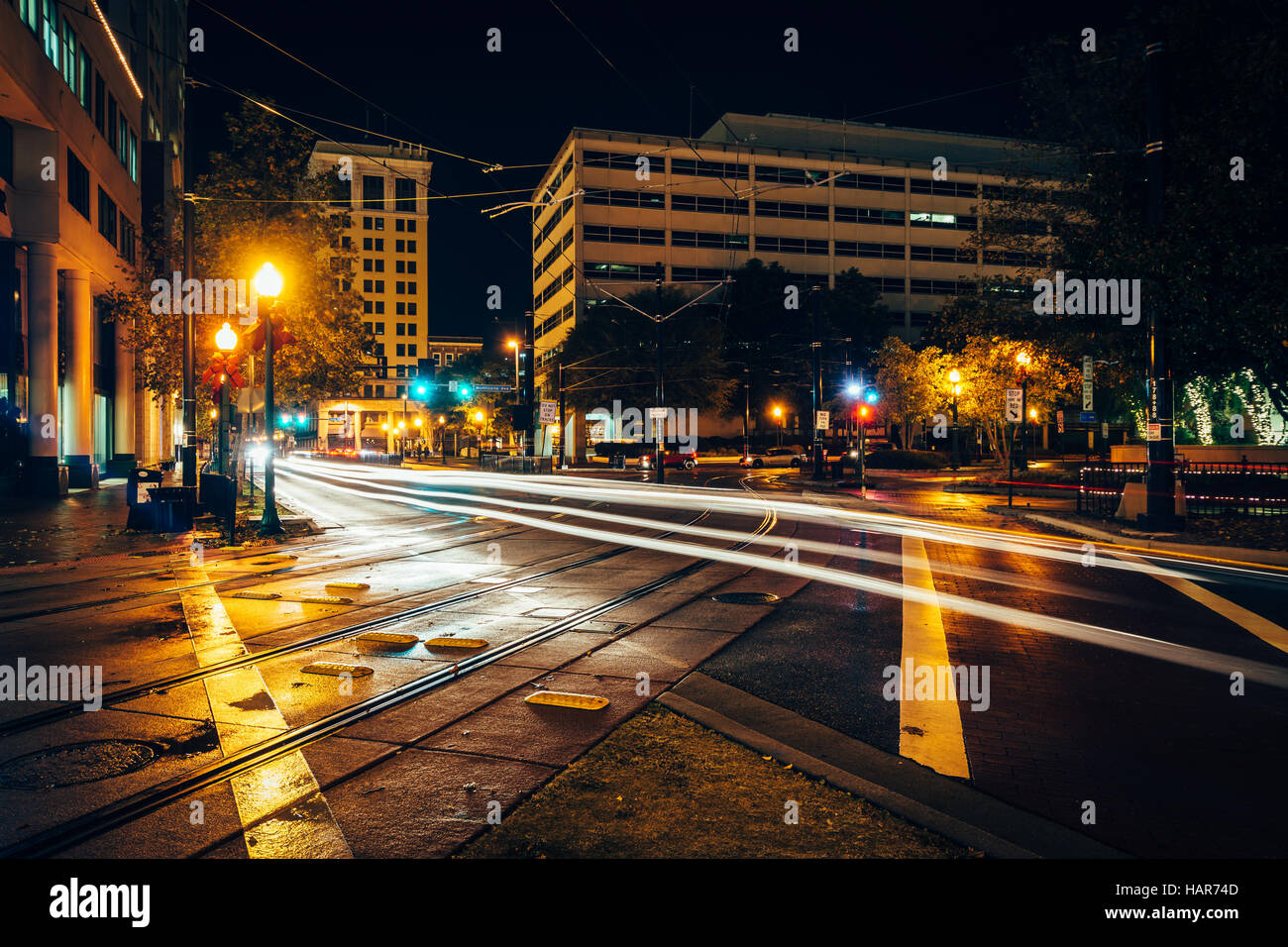 I binari del tram e gli edifici di notte in downtown Norfolk, Virginia. Foto Stock