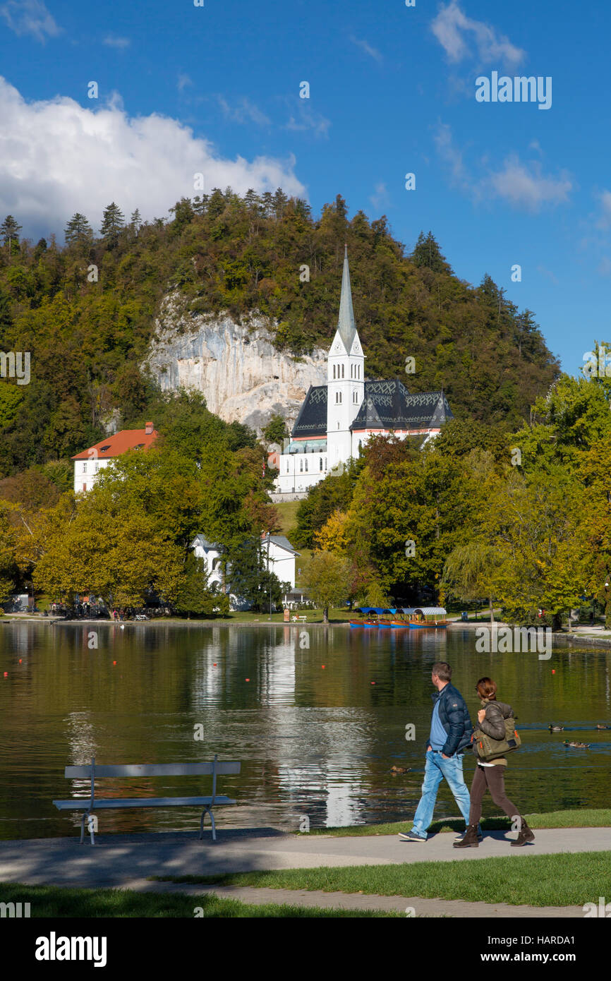 Giovane passeggiate intorno al lago di Bled con St Martin's Chiesa Parrocchiale oltre, Bled, Alta Carniola, Slovenia Foto Stock
