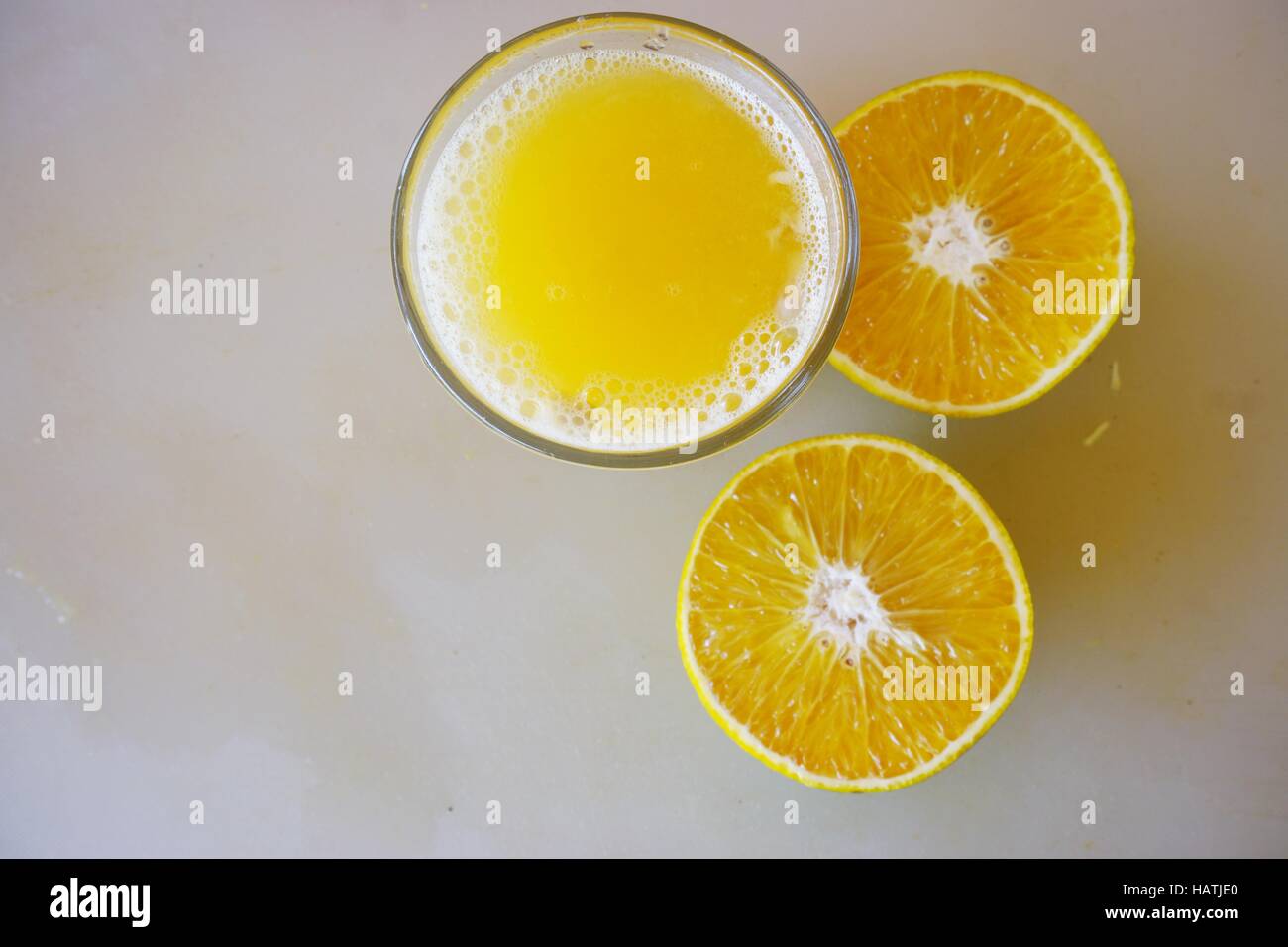 Un bicchiere di spremuta di mandarino succo con i tangerini tagliati a metà Foto Stock