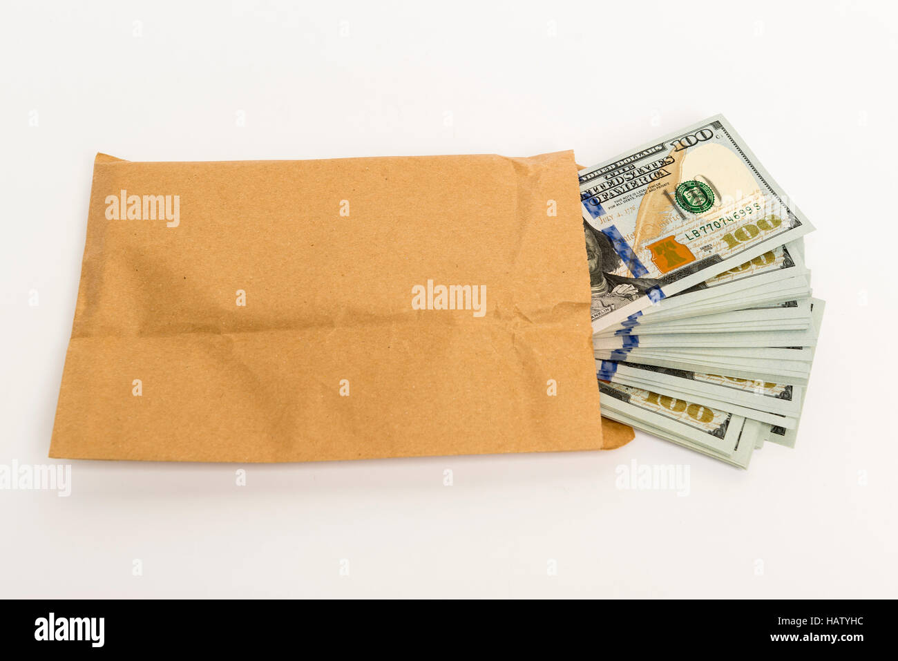 Stash di denaro in centinaia di dollari in contanti banconote provenienti al di fuori della busta Foto Stock