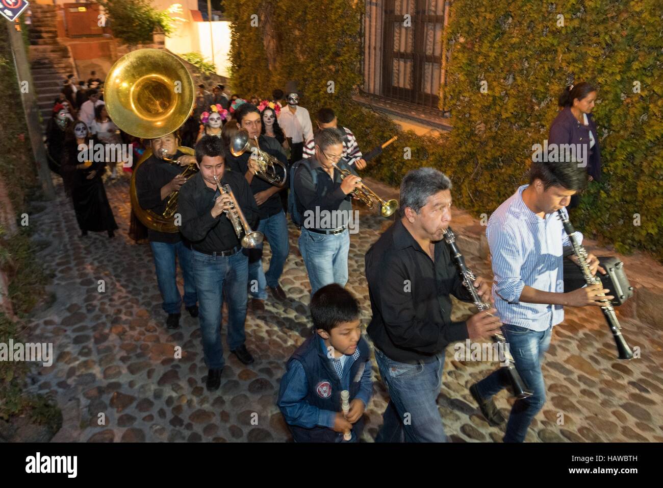 Una marching band conduce un giorno dei morti festival parade attraverso il quartiere storico di San Miguel De Allende, Guanajuato, Messico. La settimana di festa è un momento in cui i messicani benvenuti i morti alla messa a terra per una visita e celebrare la vita. Foto Stock